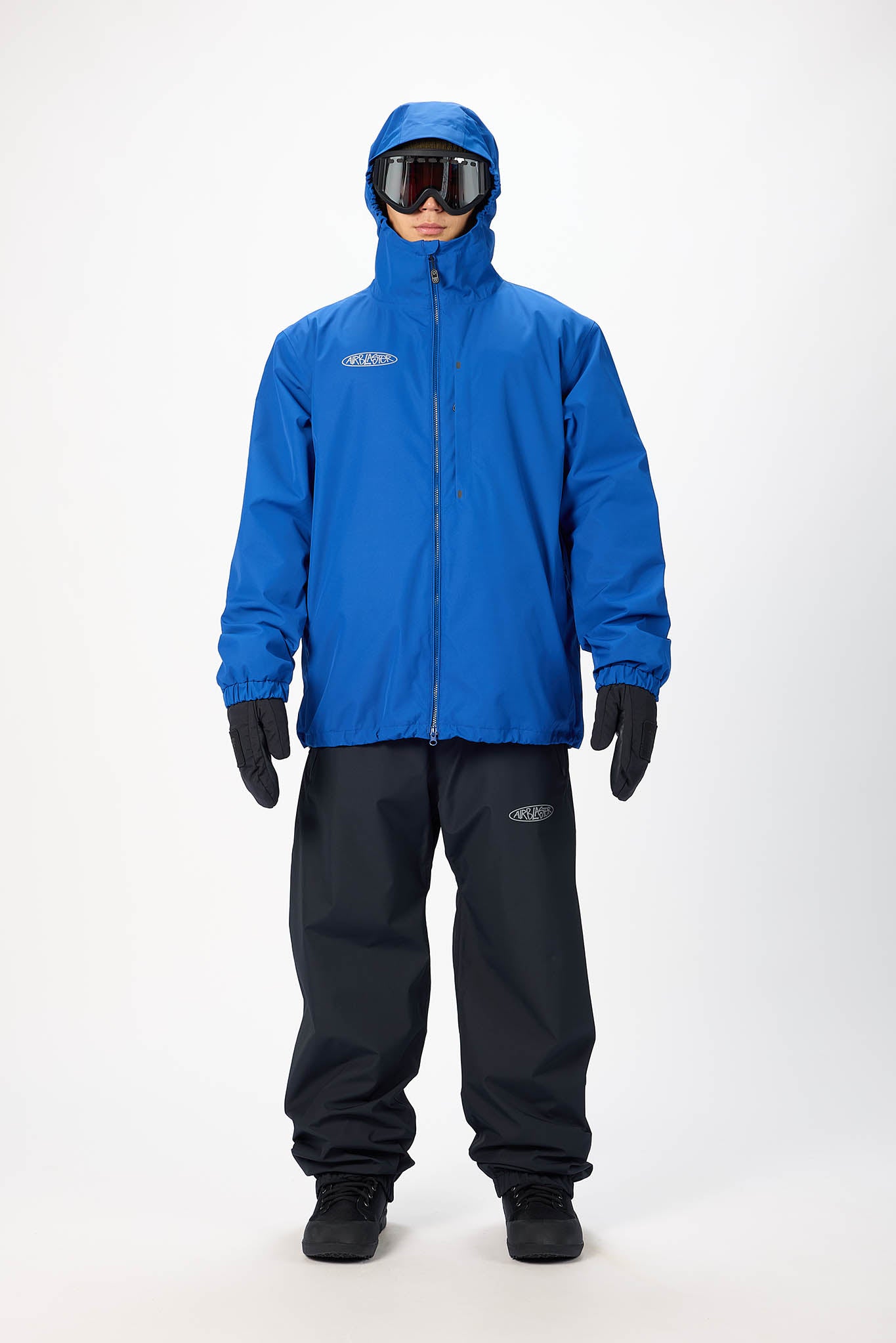 Person wearing a blue raincoat and black pants with goggles on a white background
