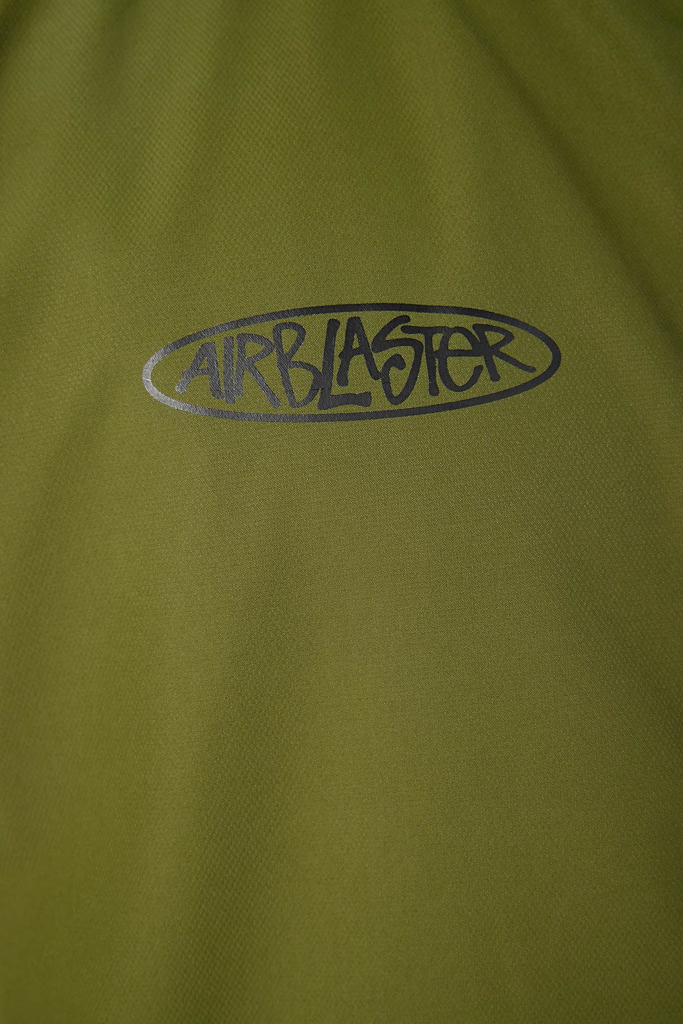 Close-up of a green fabric with 'Airblaster' logo.