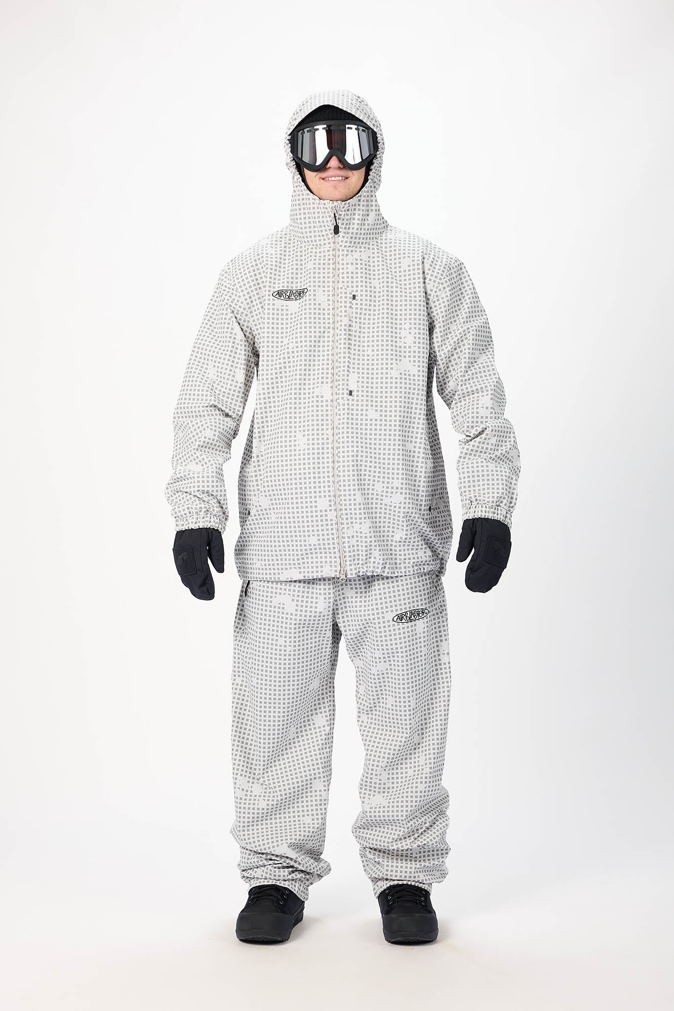Person wearing a gray checkered raincoat and pants with goggles on a white background