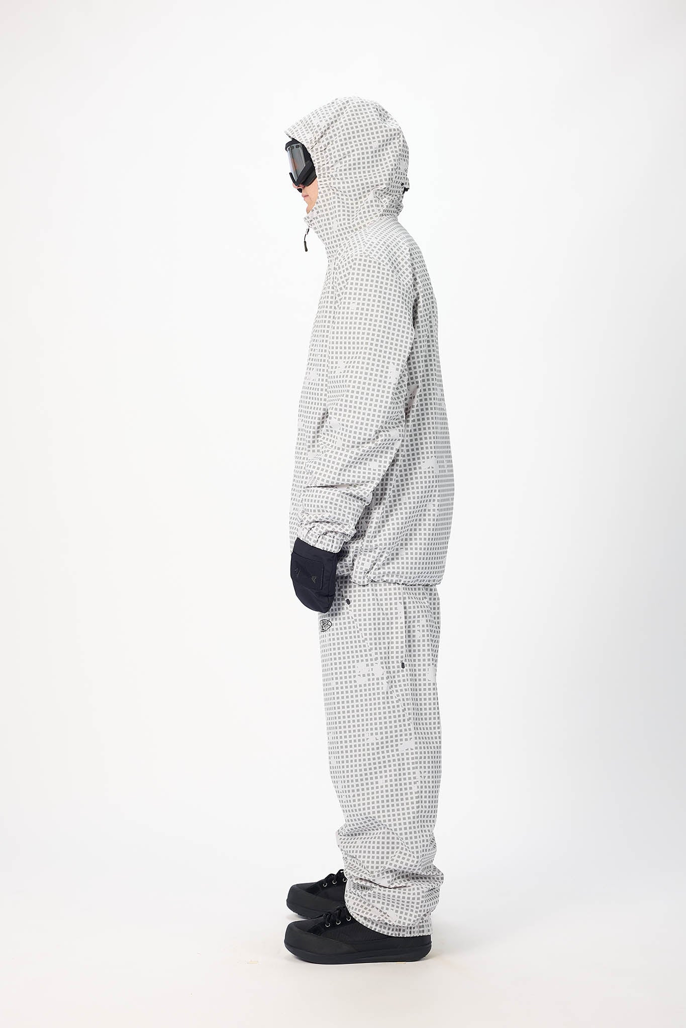 Person wearing a checkered snowsuit on a white background