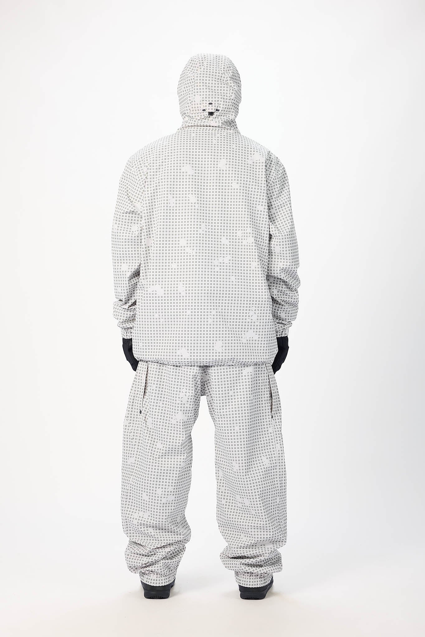 Person wearing a gray checkered jumpsuit on a white background