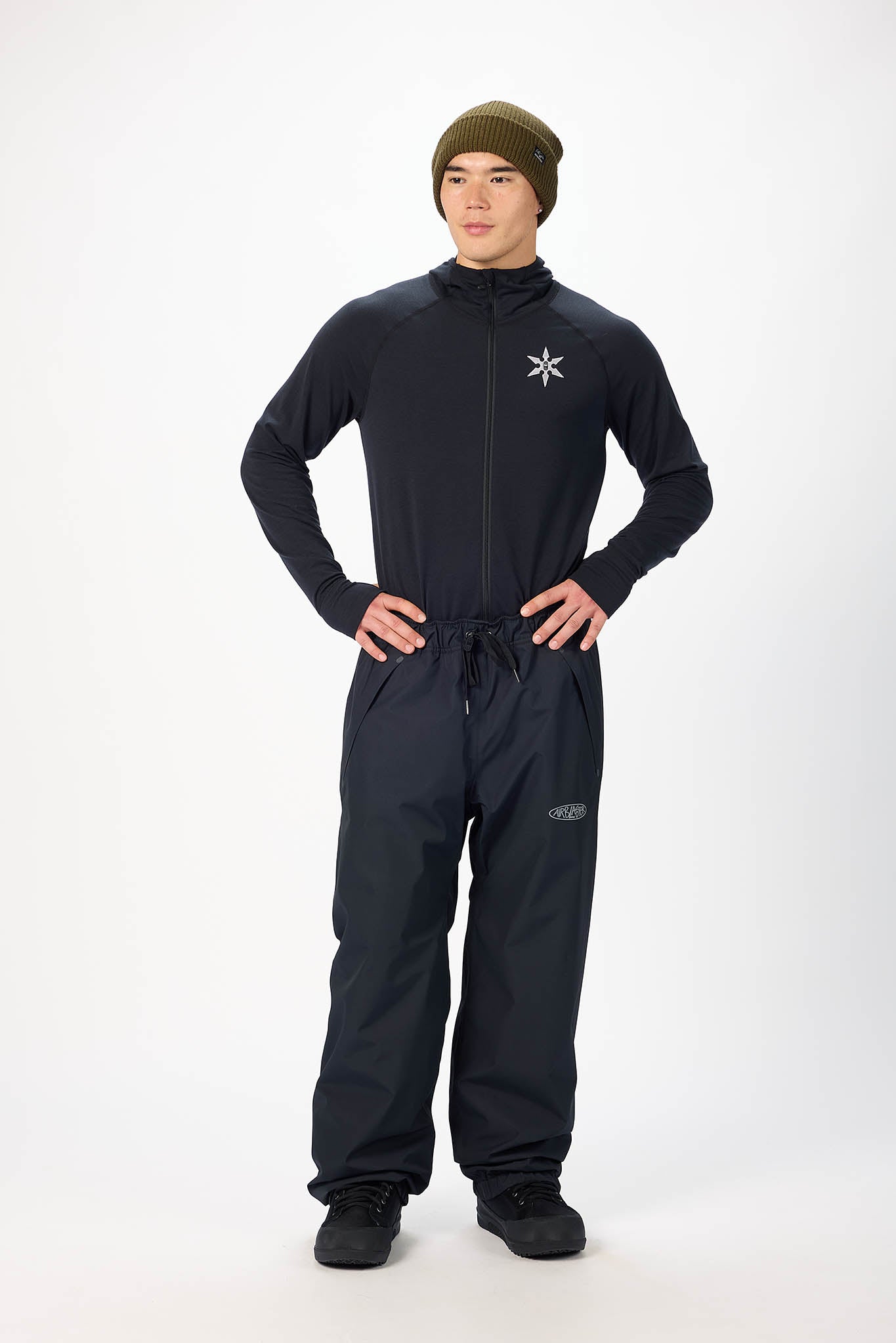 Person wearing a black snowsuit with a logo on a white background