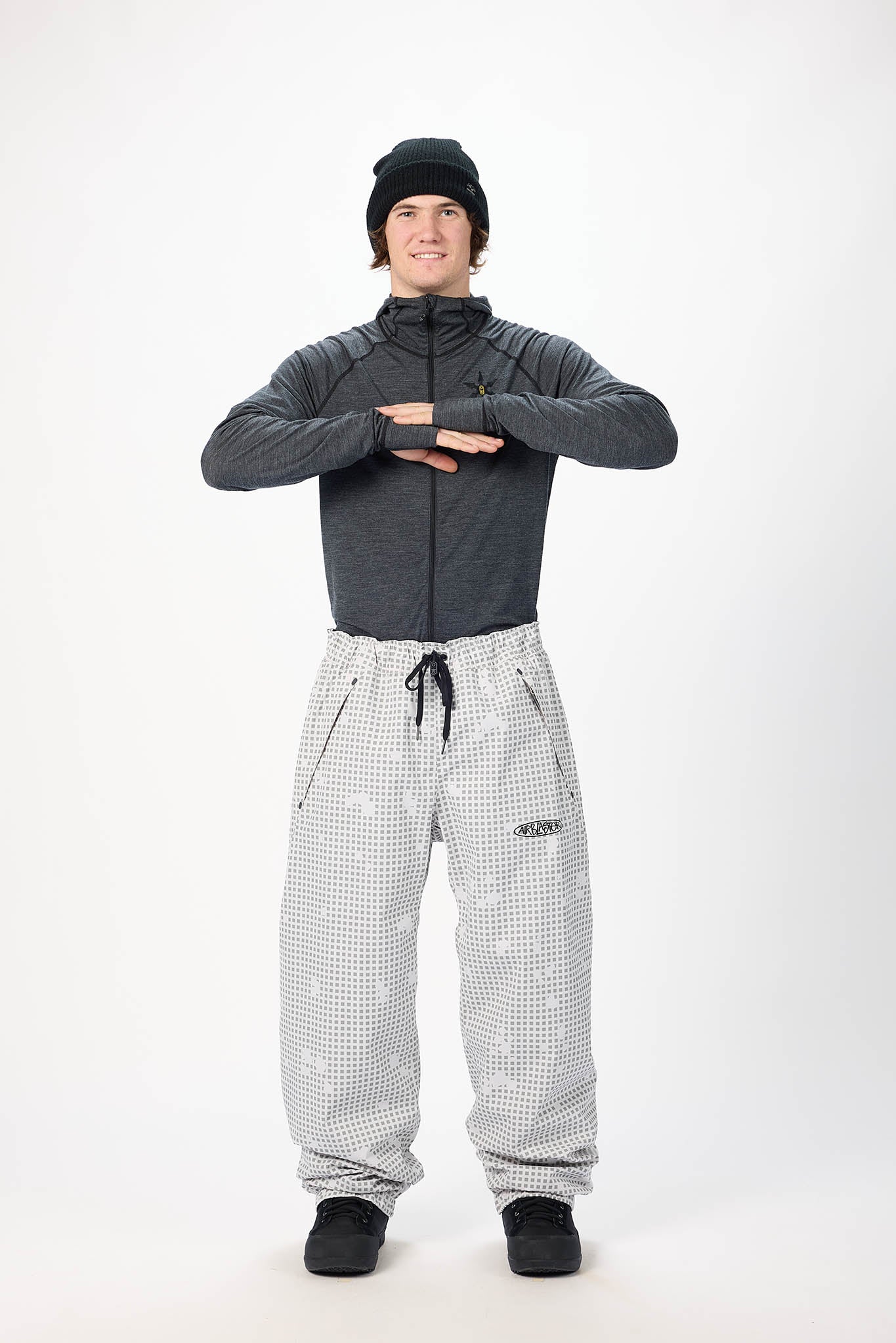 Person wearing a gray jacket and checkered pants on a white background
