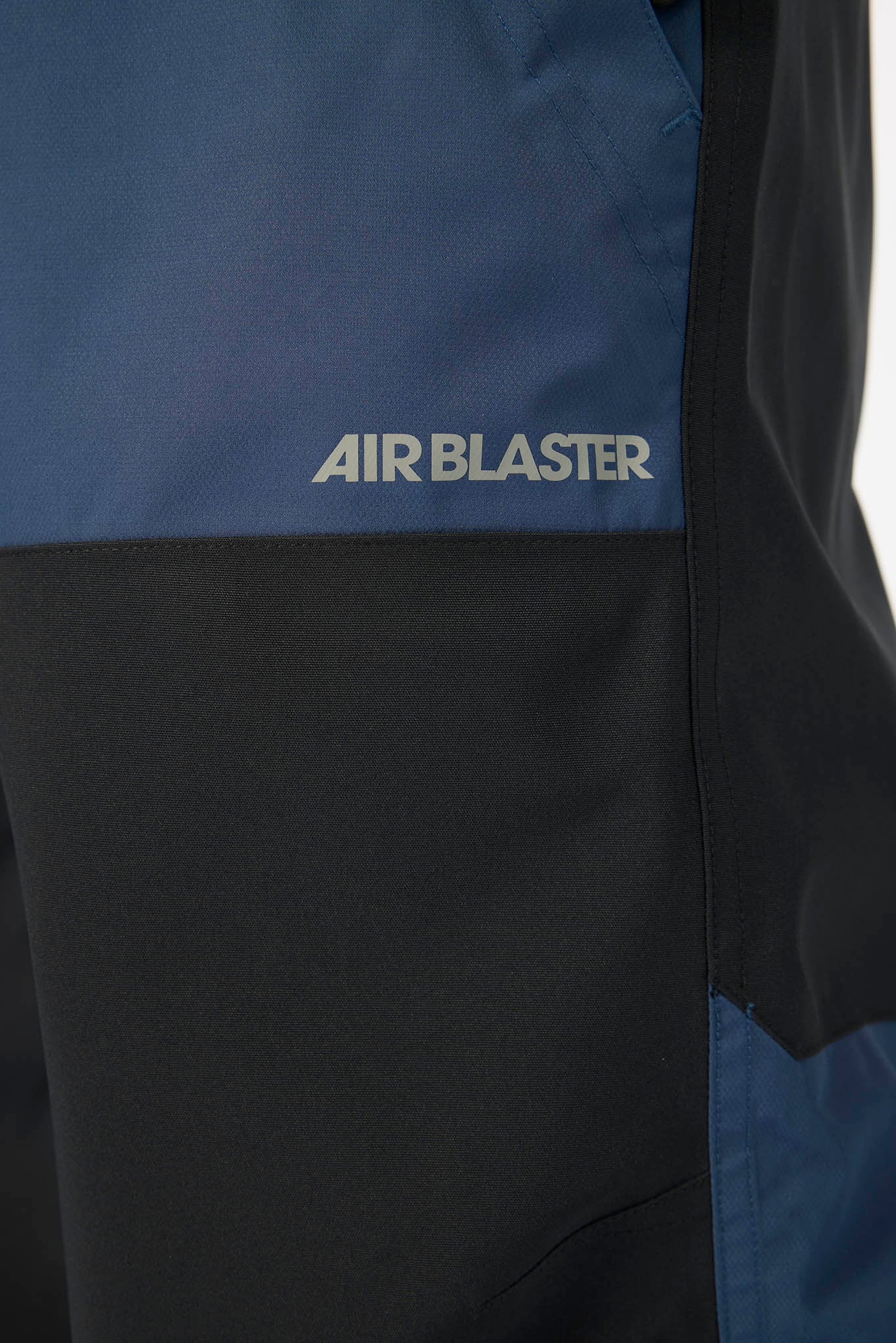 Close-up of a blue and black jacket with 'AIR BLASTER' branding.