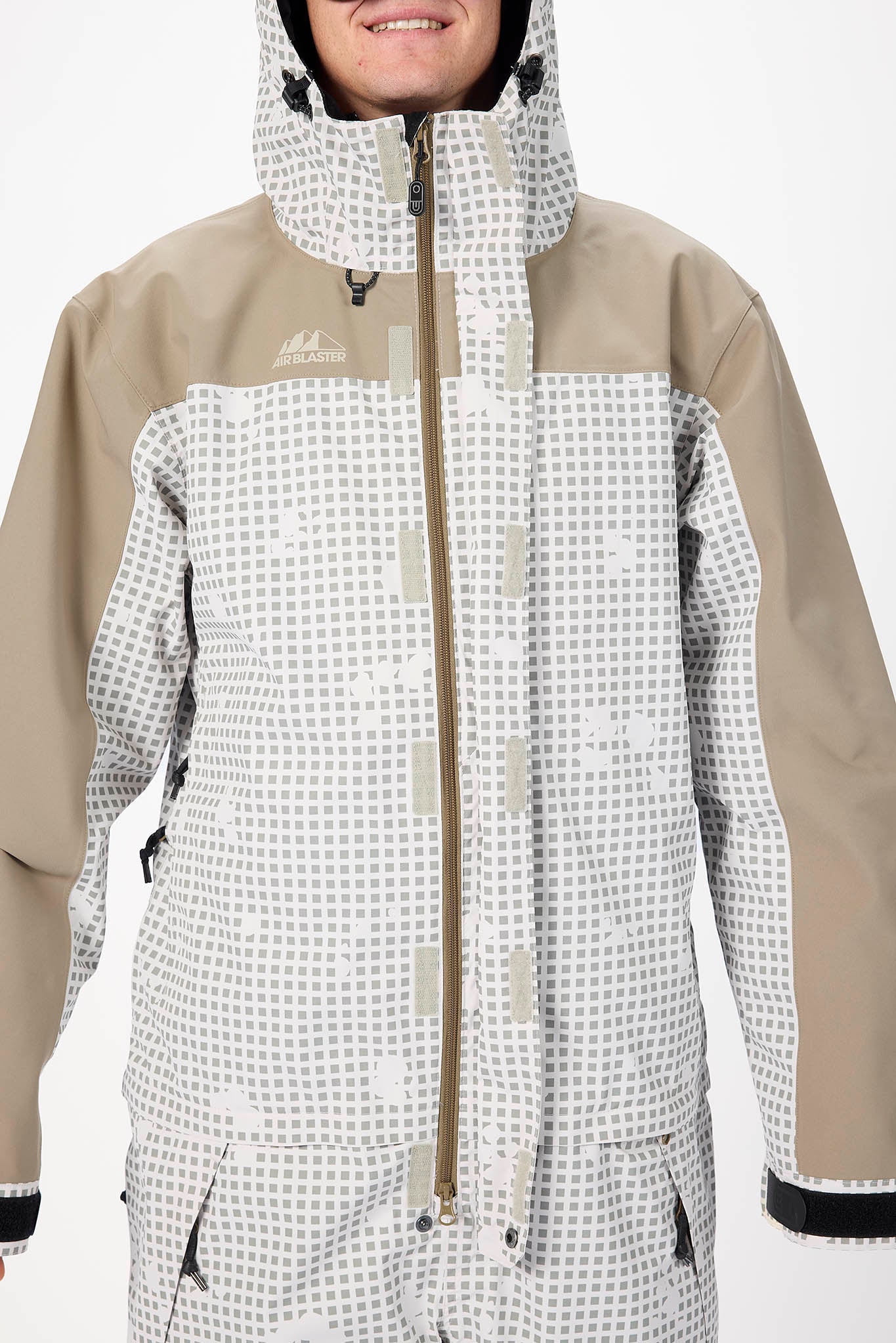 Person wearing a beige and white checkered snowsuit with a hood on a white background