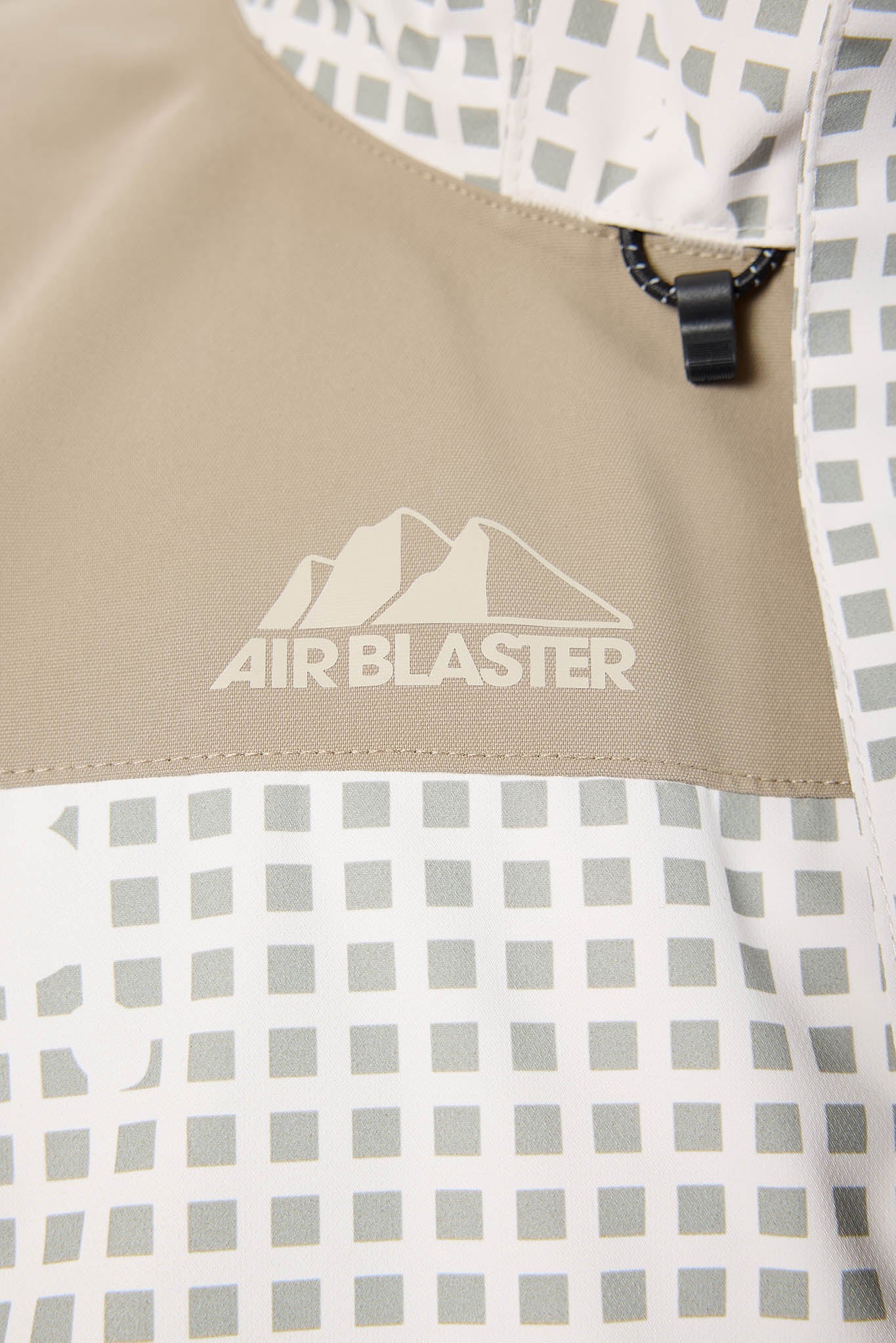 Close-up of a product with 'Air Blaster' logo on a beige and checkered background