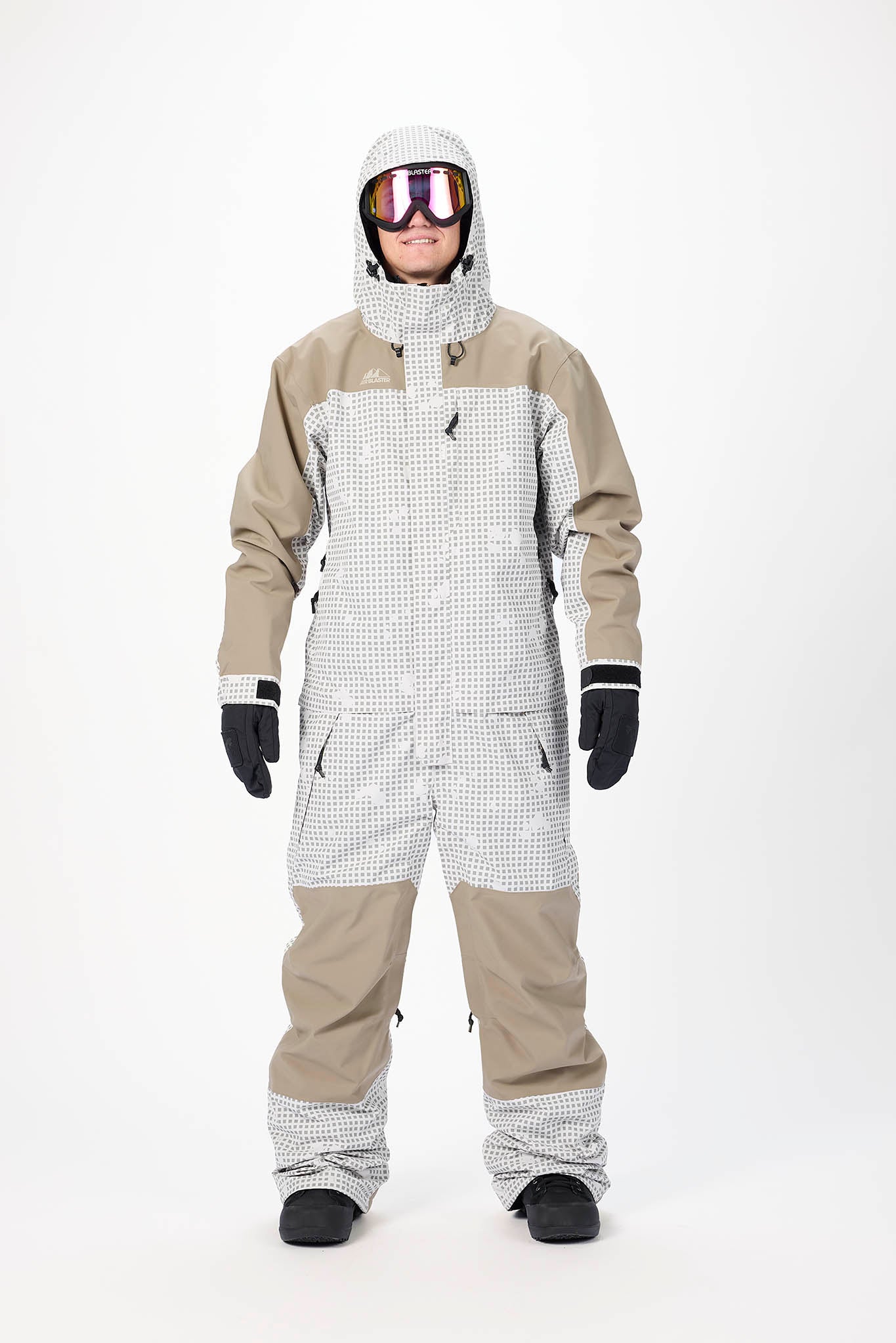 Person wearing a beige and white snowsuit with goggles on a white background