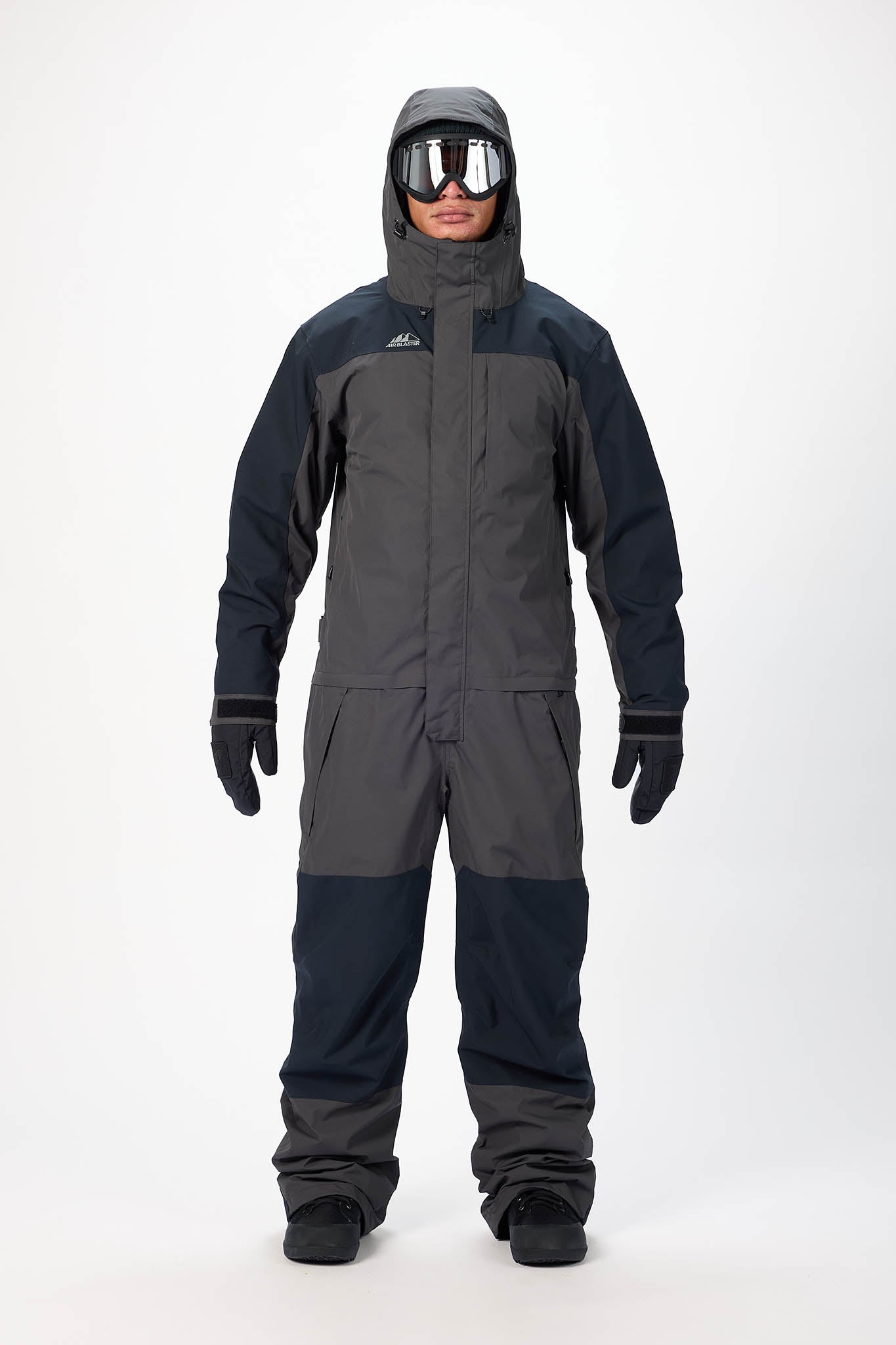 Person wearing a gray and black snowsuit with goggles on a white background