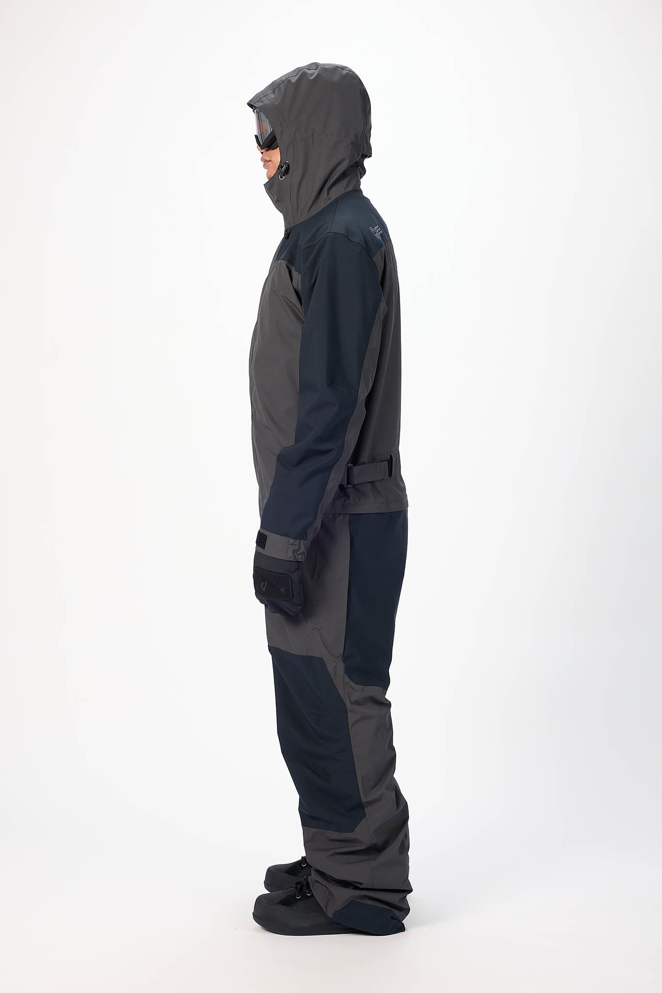 Person wearing a gray and black hooded suit on a white background