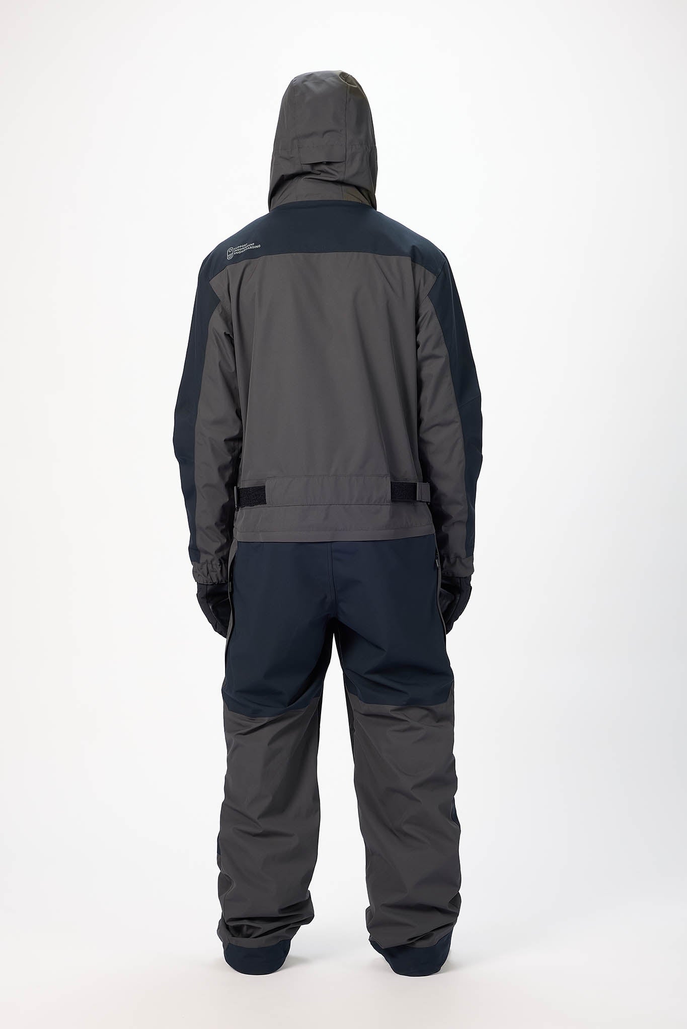 Person wearing a gray and black snowmobile suit on a white background