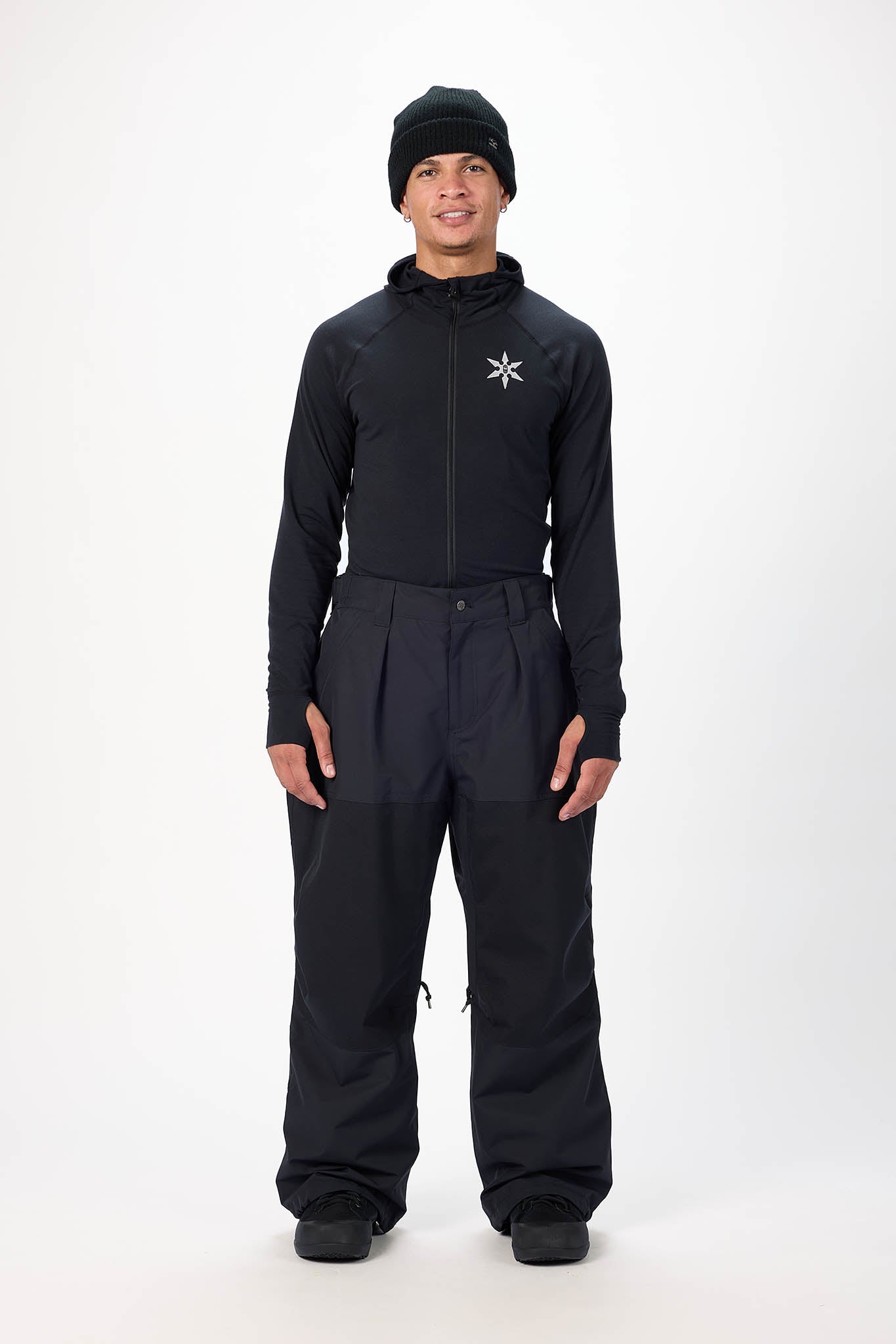 Person wearing a black snowsuit with a star logo on a white background
