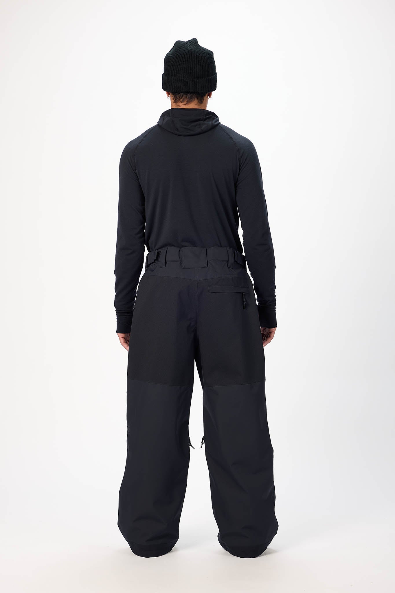 Person wearing a black outfit with a hood on a white background
