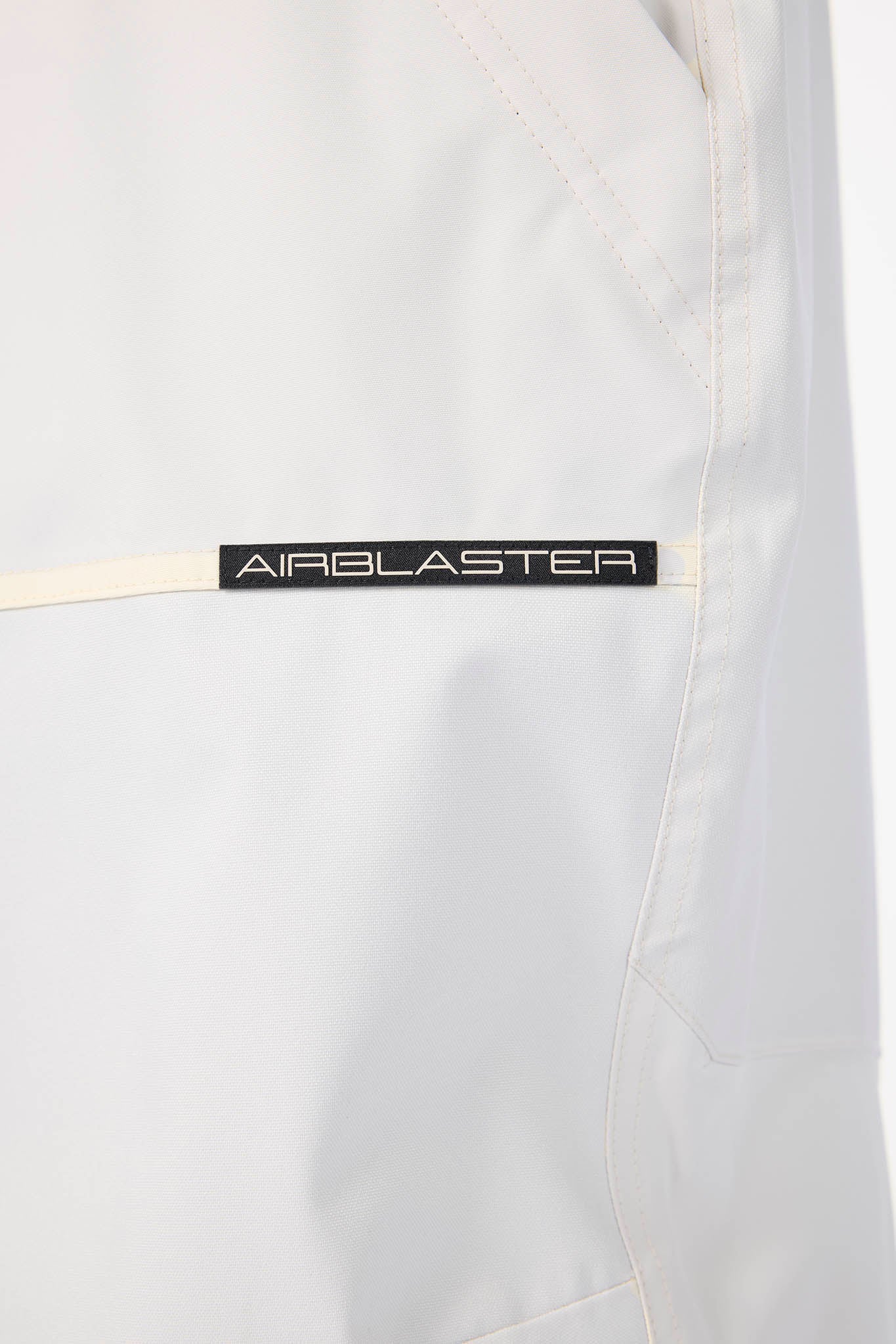 Close-up of a white jacket with 'Airblaster' branding on a white background