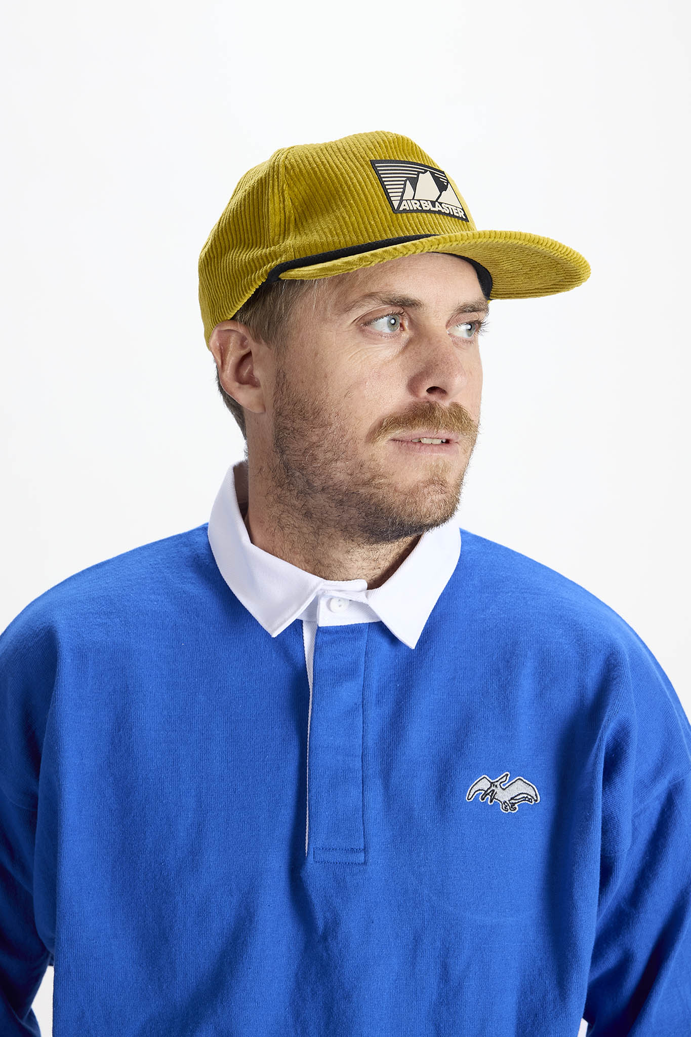 A woman wearing a yellow baseball cap, photographed against a plain white background.