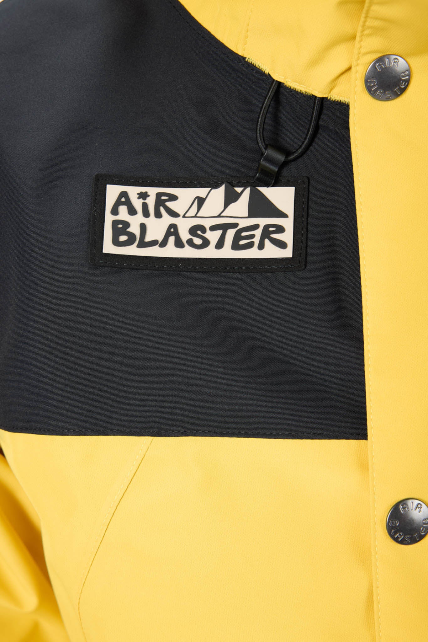 Close-up of a yellow jacket with a black patch featuring 'Air Blaster' branding.