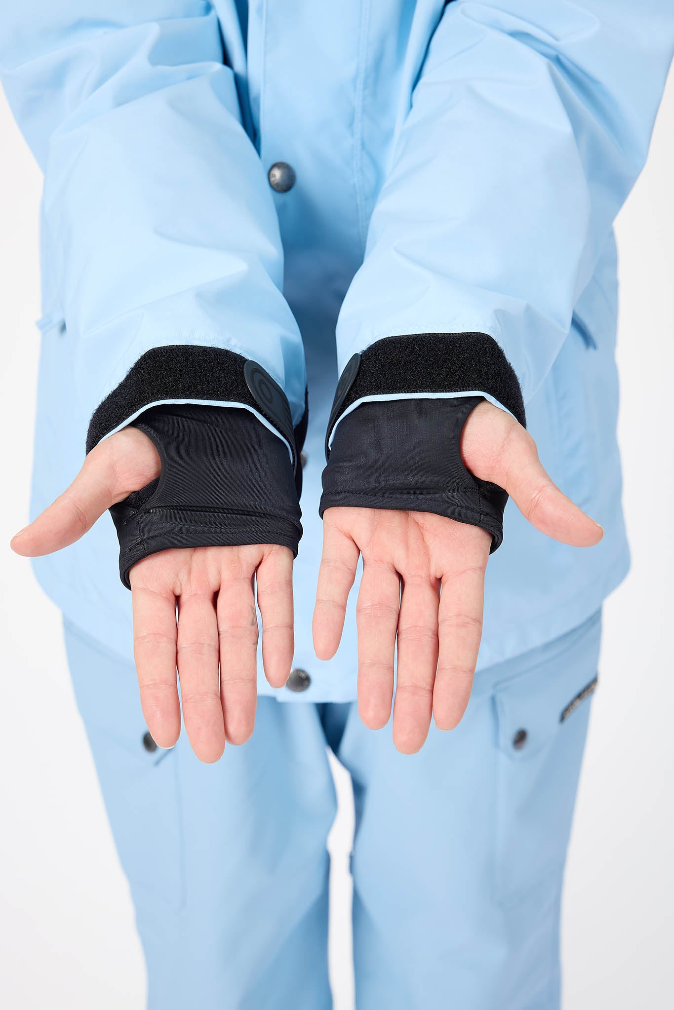Person wearing black wrist wraps on a white background