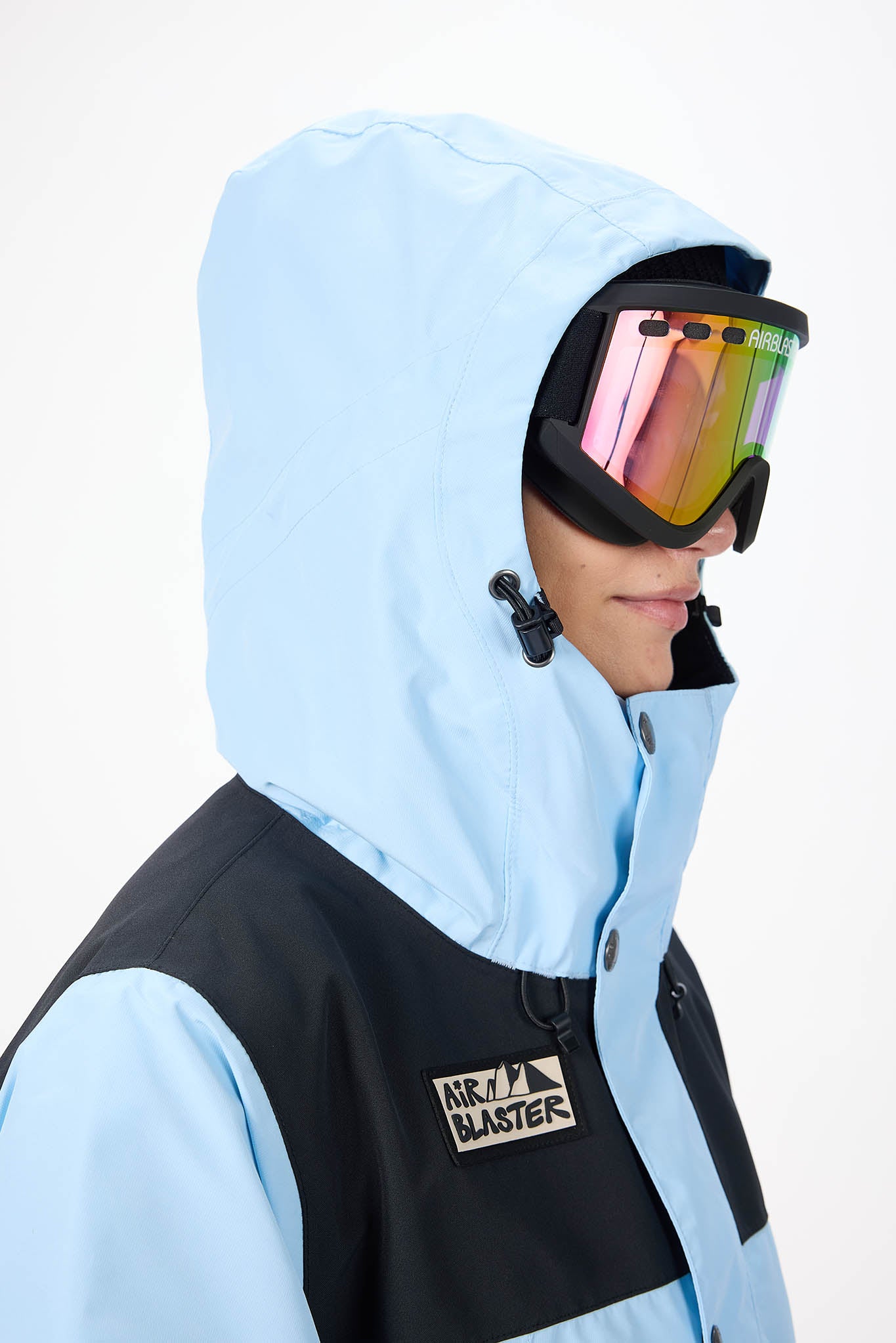 Person wearing a light blue snow jacket with a hood and goggles, featuring the Bladerunner brand.