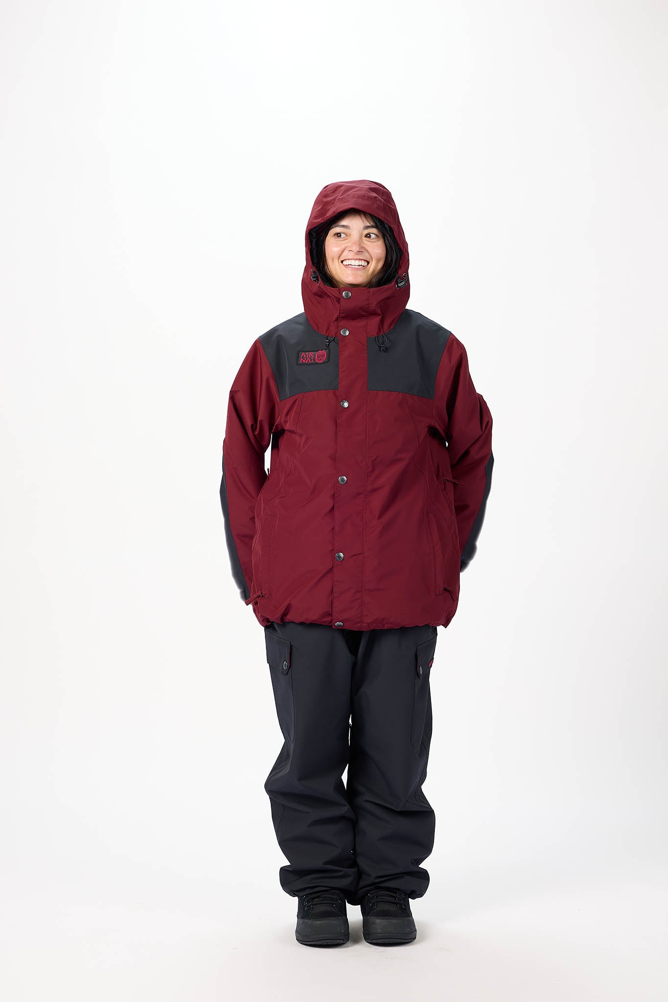 Person wearing a red and black jacket with a hood on a white background