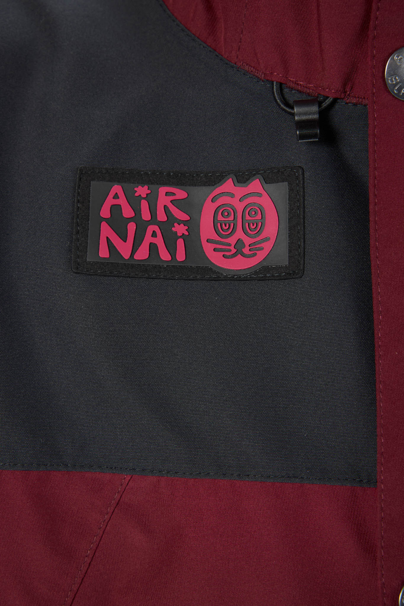 Close-up of a black patch with red text and design on a dark jacket.