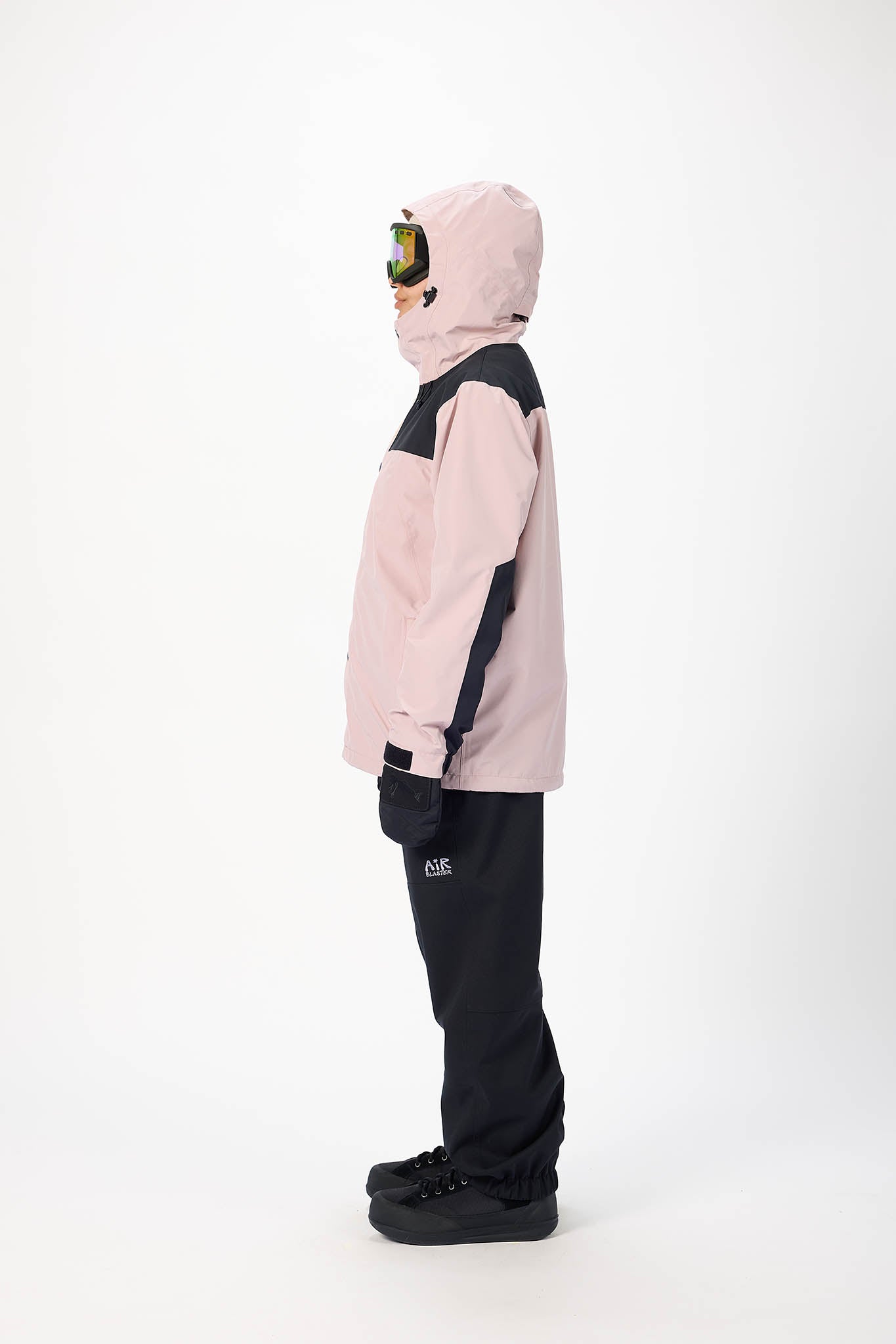 Person wearing a pink and black snowboarding outfit on a white background