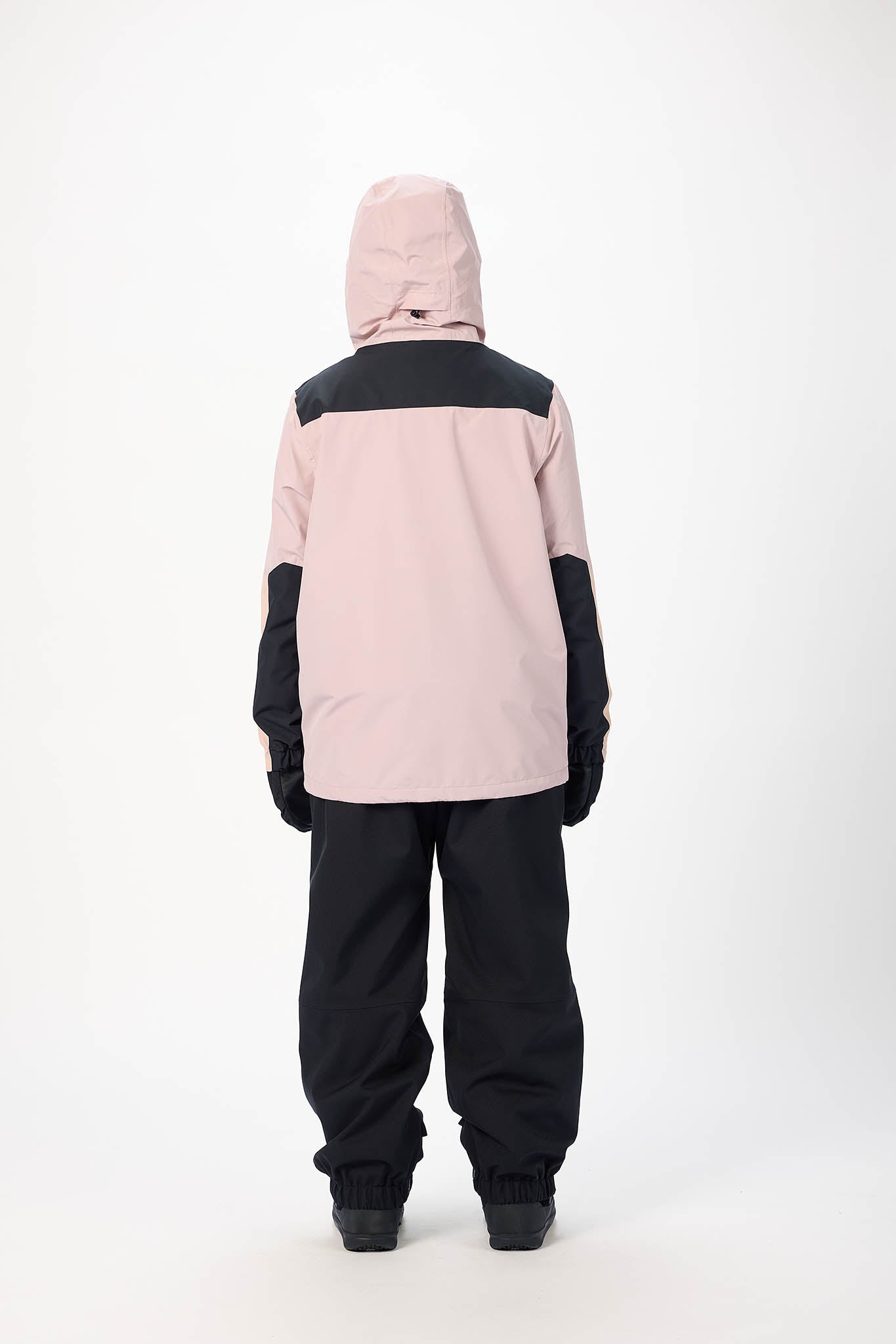 Person wearing a pink and black snowsuit on a white background