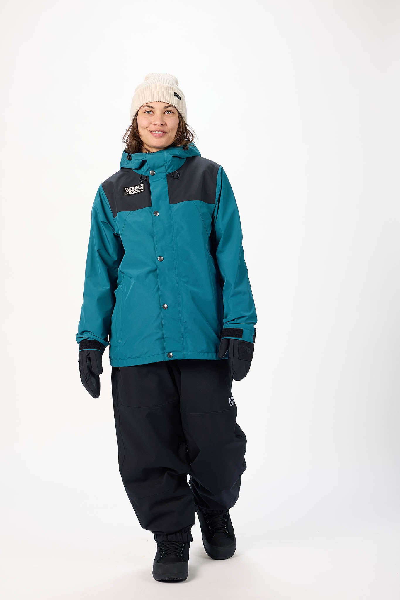Person wearing a light blue and black snow jacket with matching pants on a white background