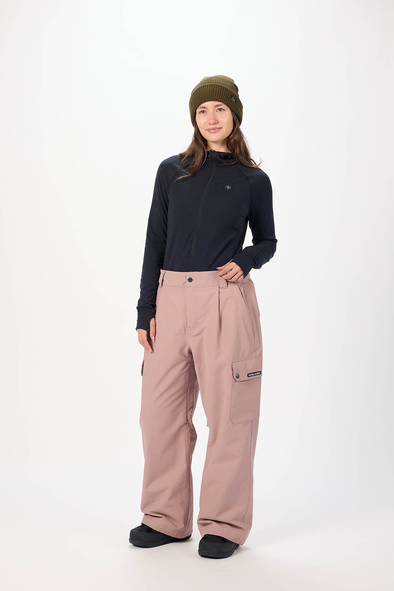 Person wearing a black long-sleeve top and pink pants on a white background