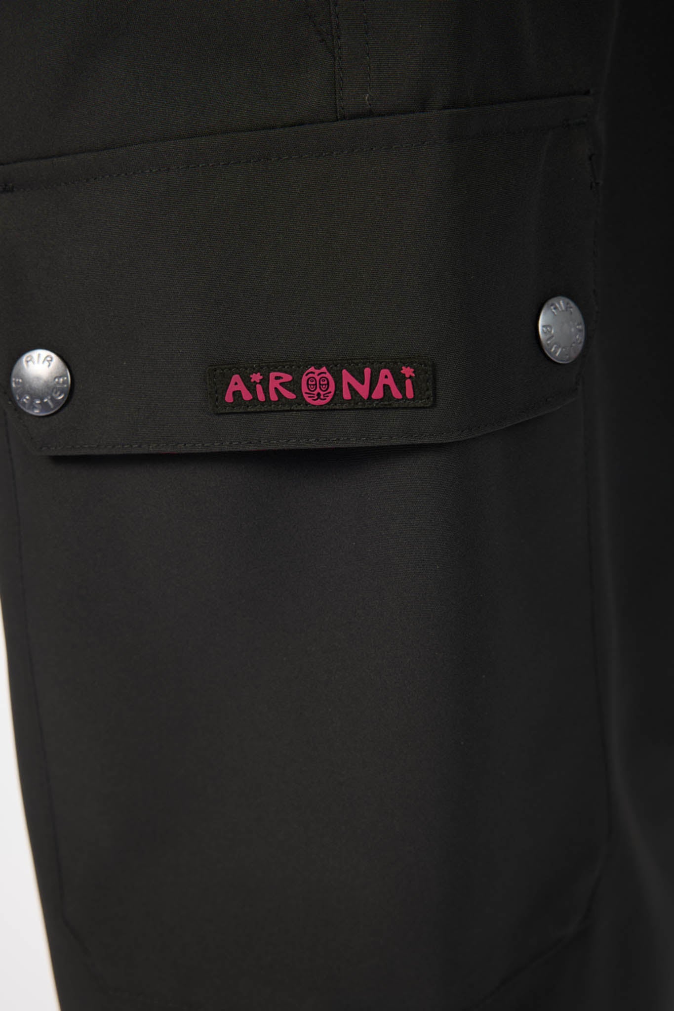 Close-up of a black jacket pocket with a brand logo on a white background