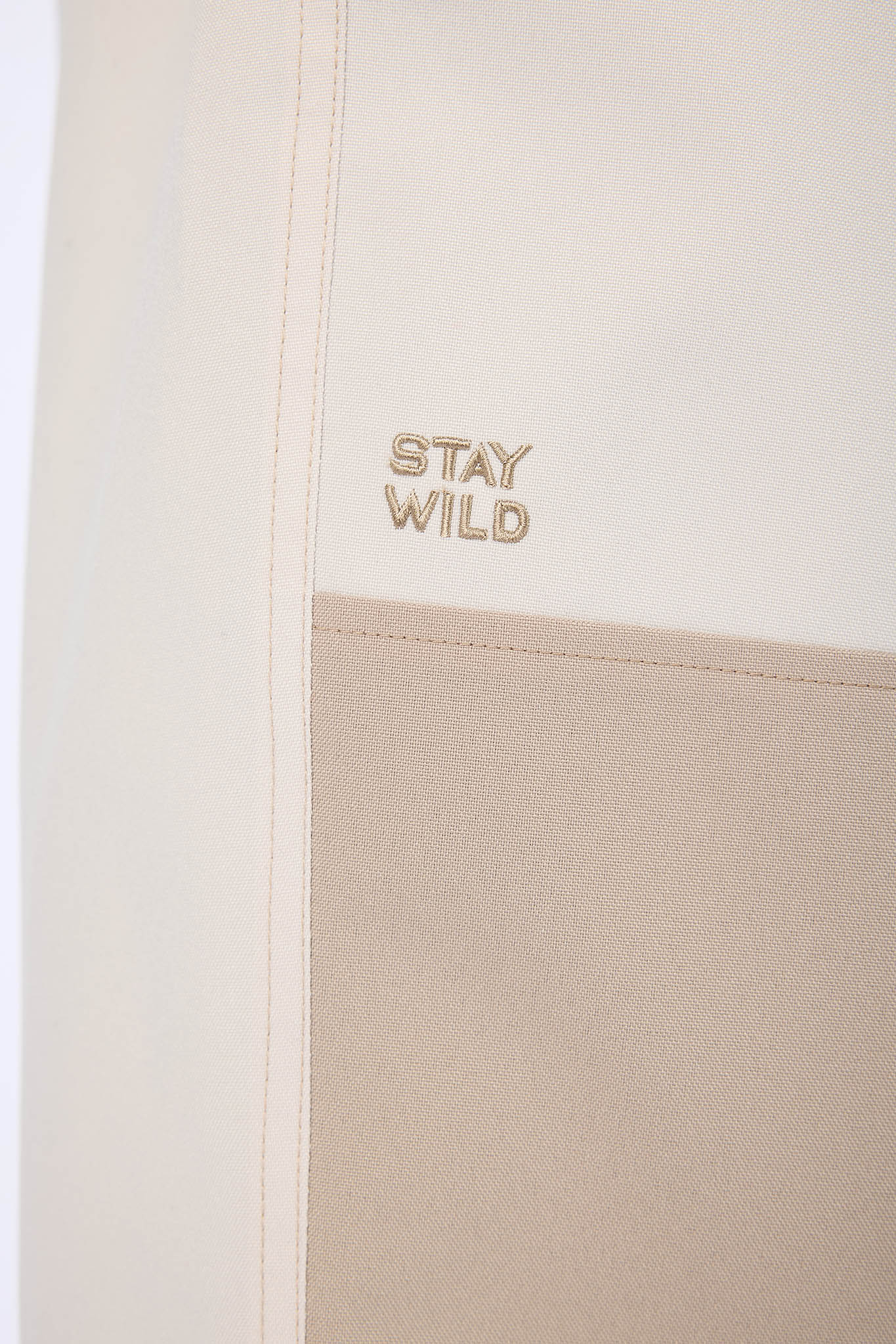 Beige pouch with 'Stay Wild' text on a white background