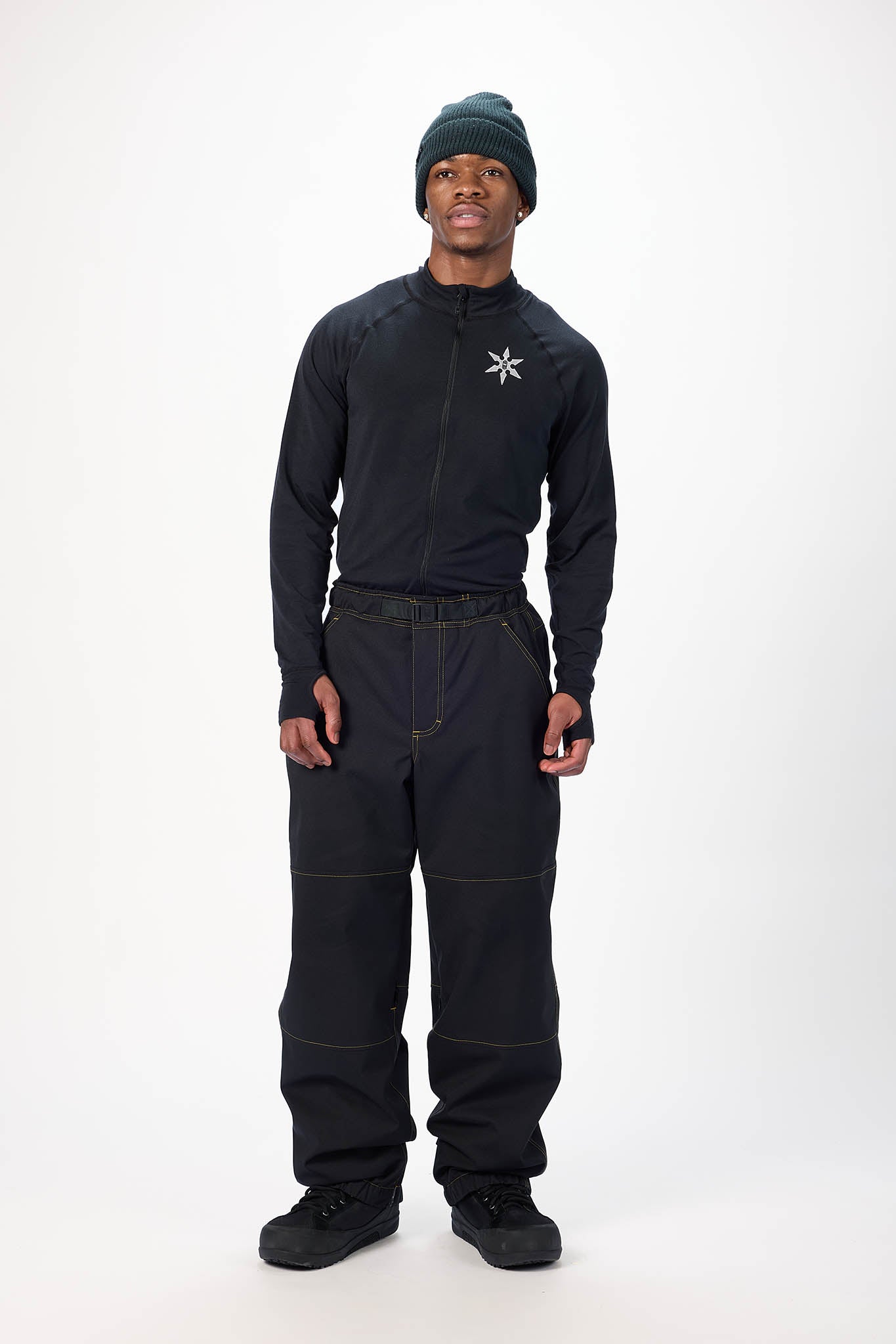 Person wearing a black snowsuit with a white logo on a white background