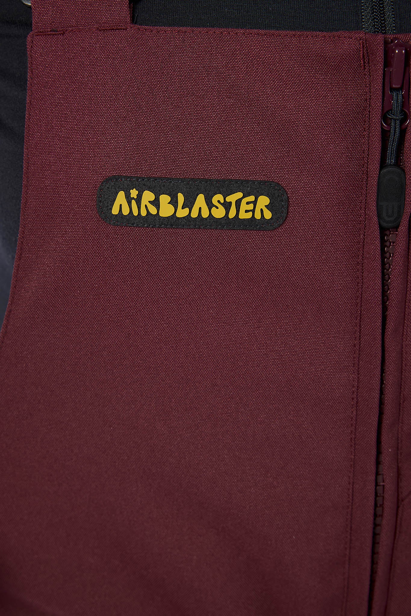 Maroon bag with Airblaster logo on a dark background
