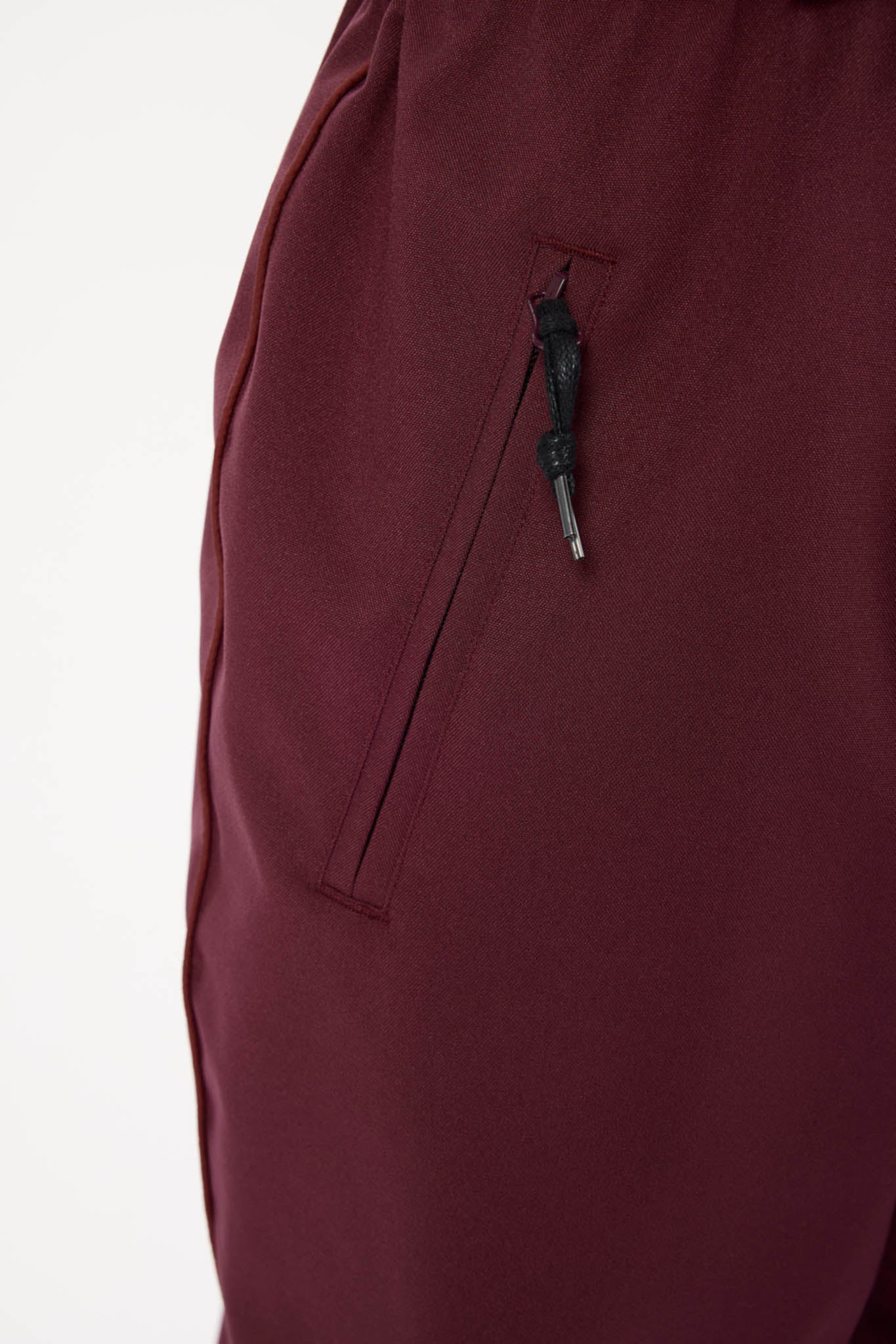 Maroon pants with a pocket on a white background