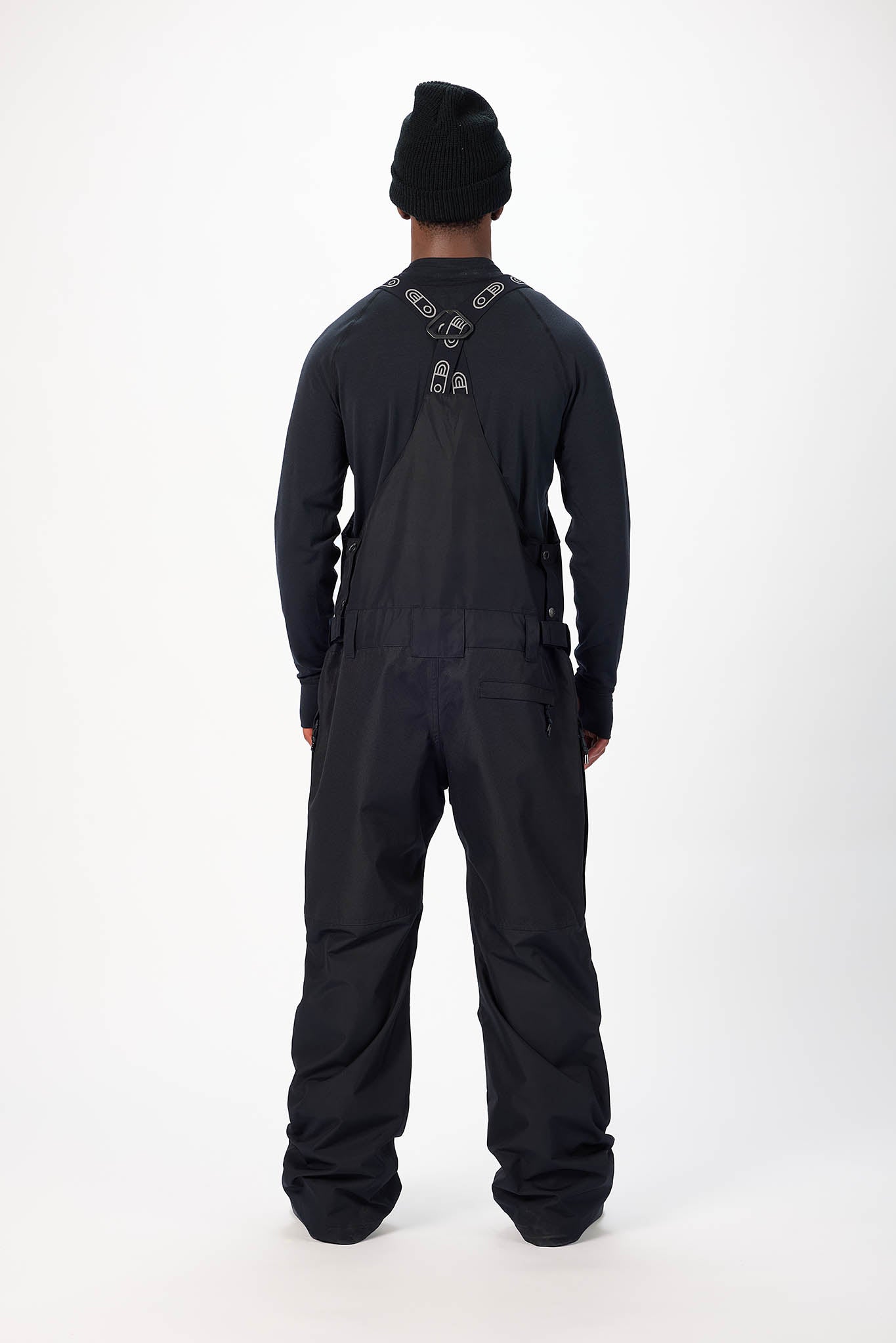 Person wearing a black overalls suit on a white background