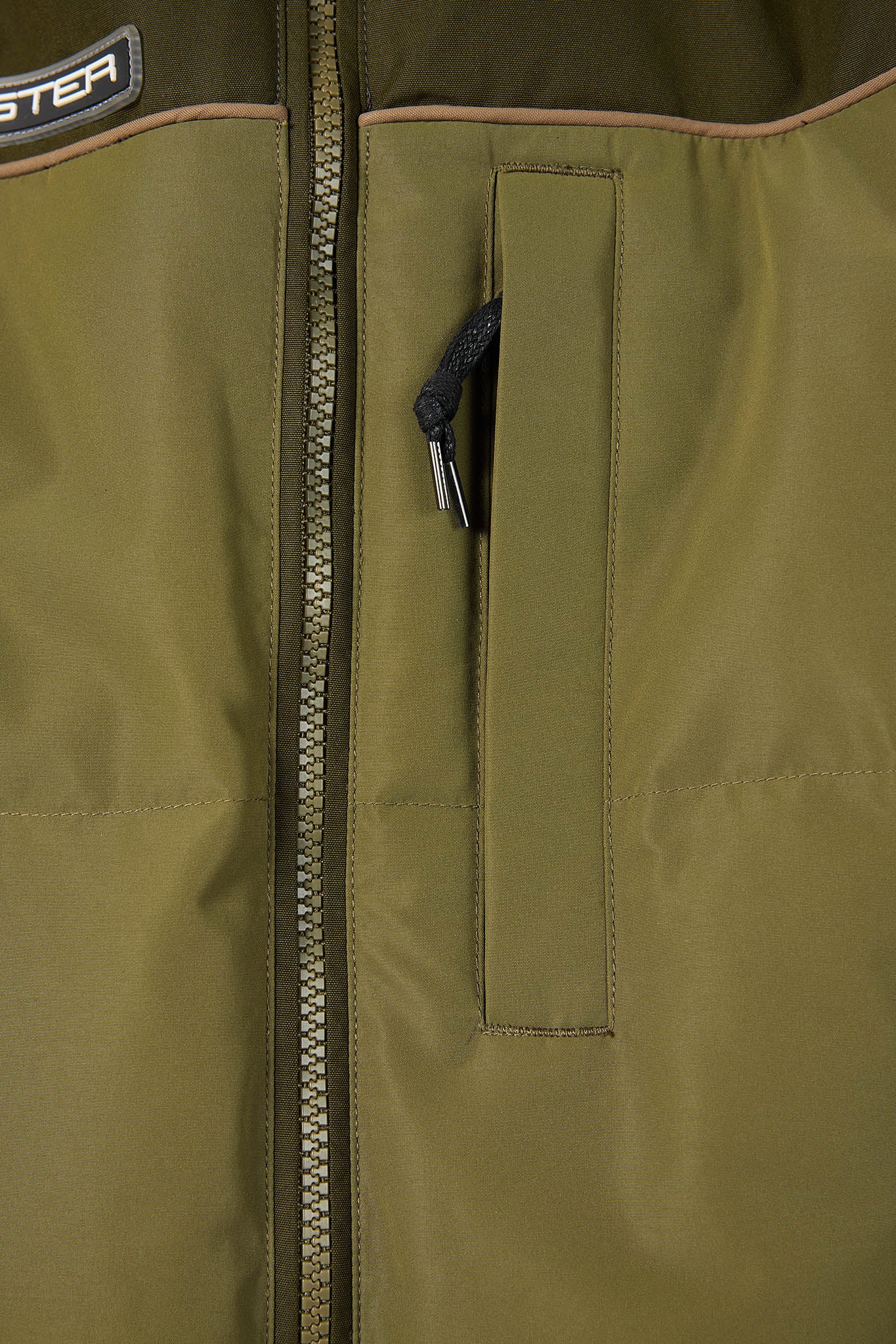 Close-up of a green jacket with a zipper and brand logo.