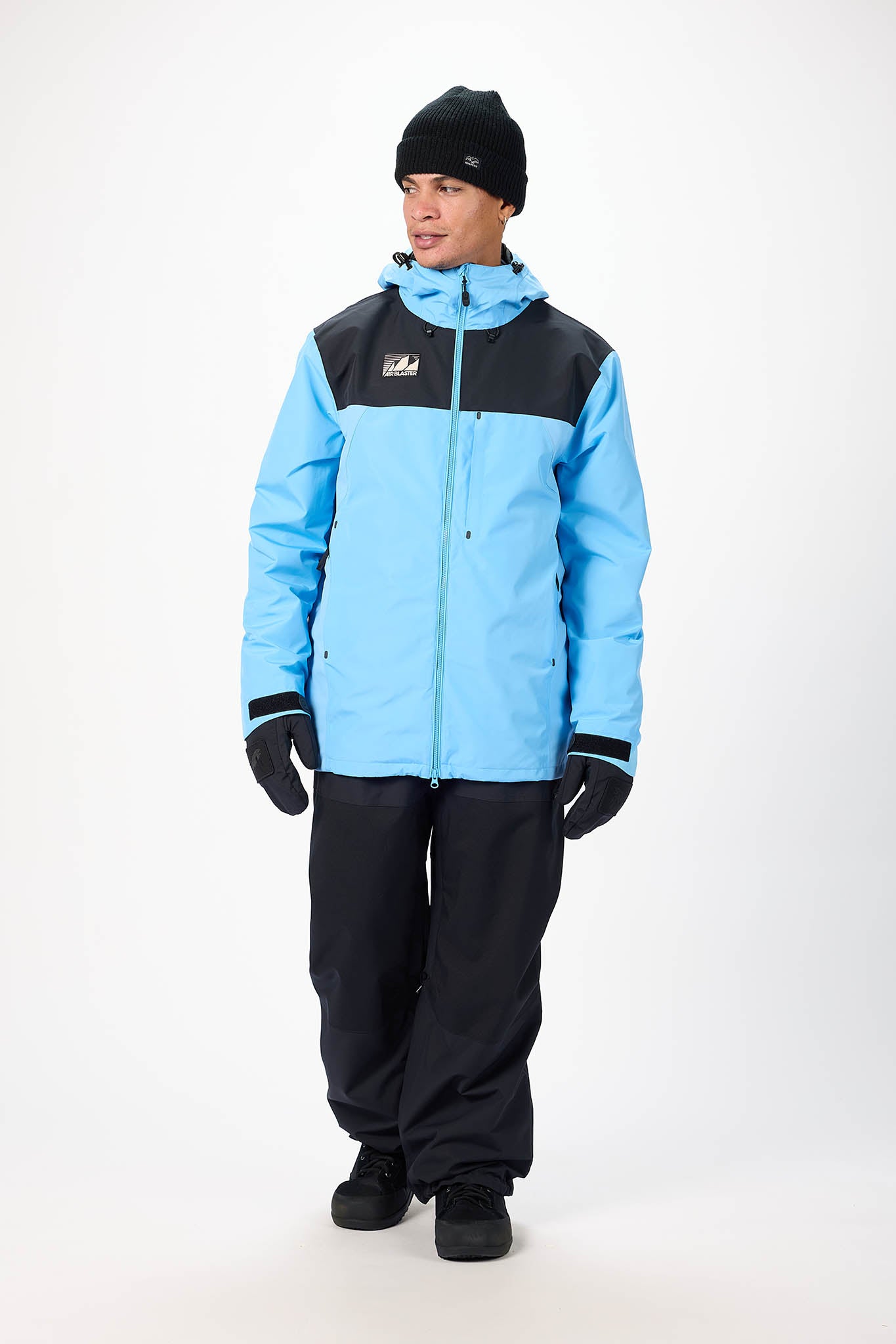 Person wearing a blue and black snowsuit on a white background