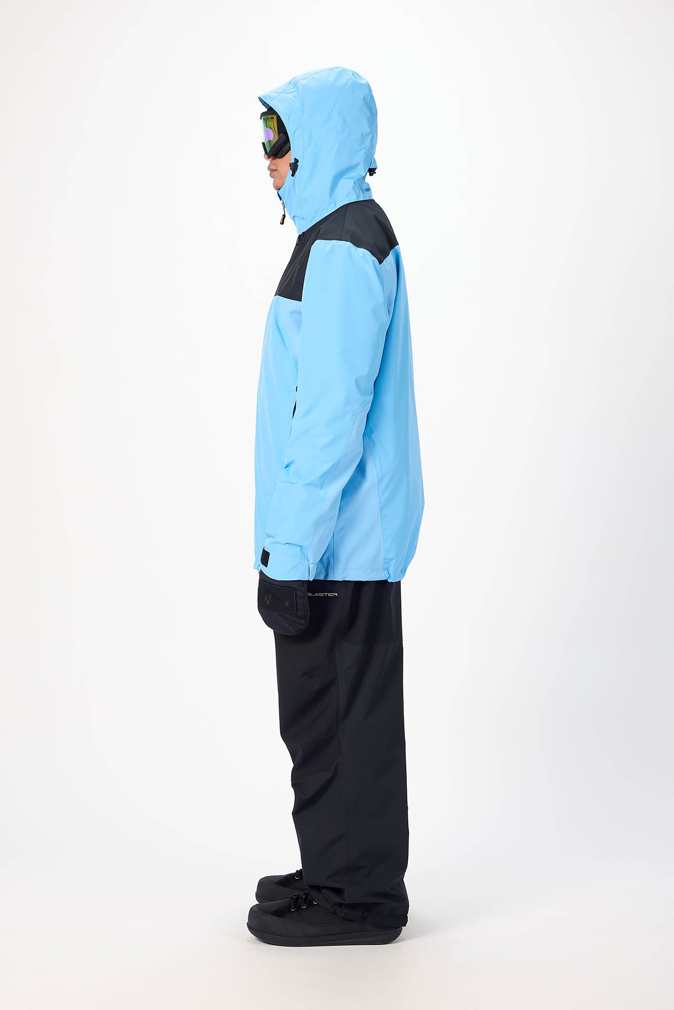 Person wearing a light blue snow jacket with black pants on a white background