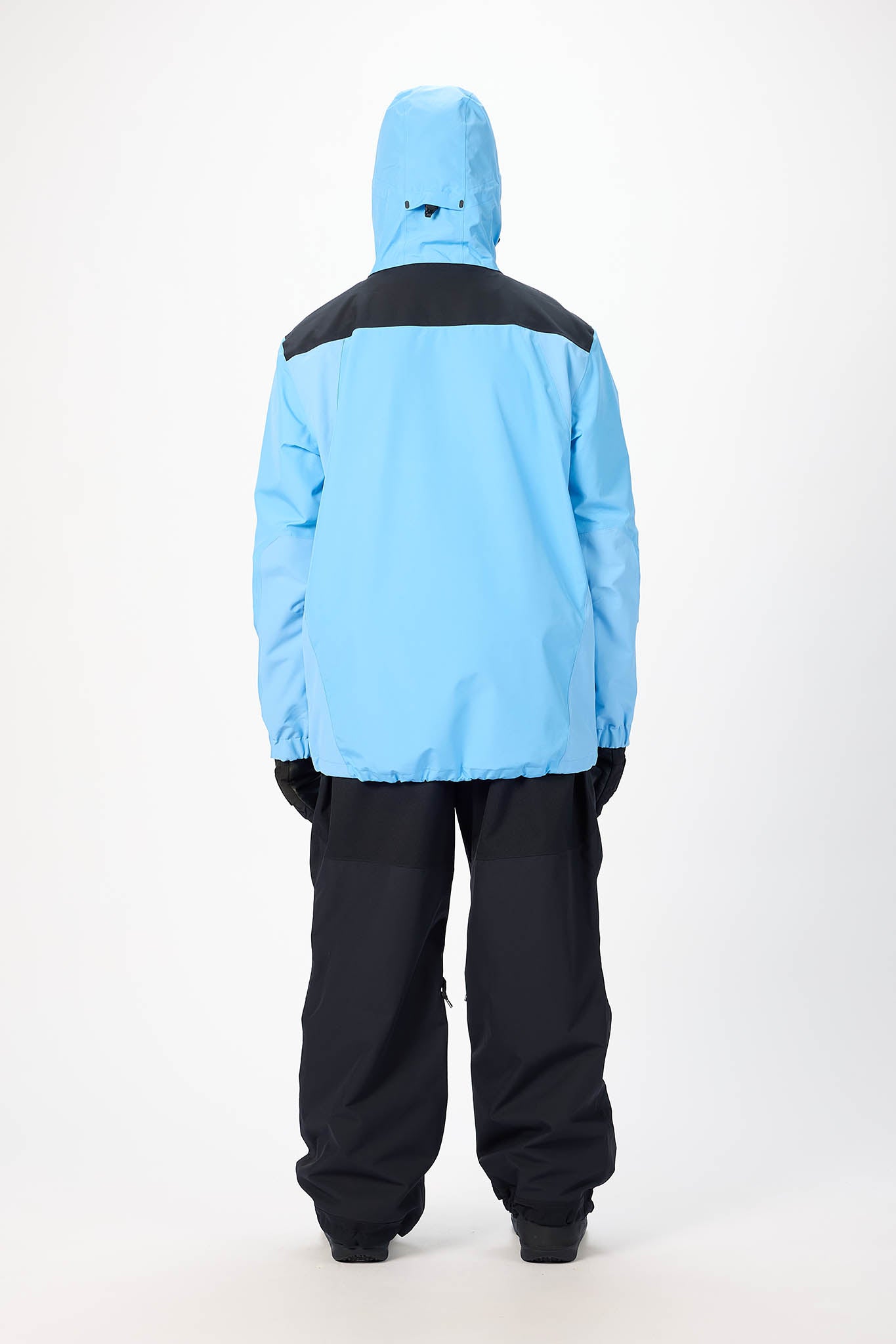 Person wearing a blue and black snowsuit on a white background