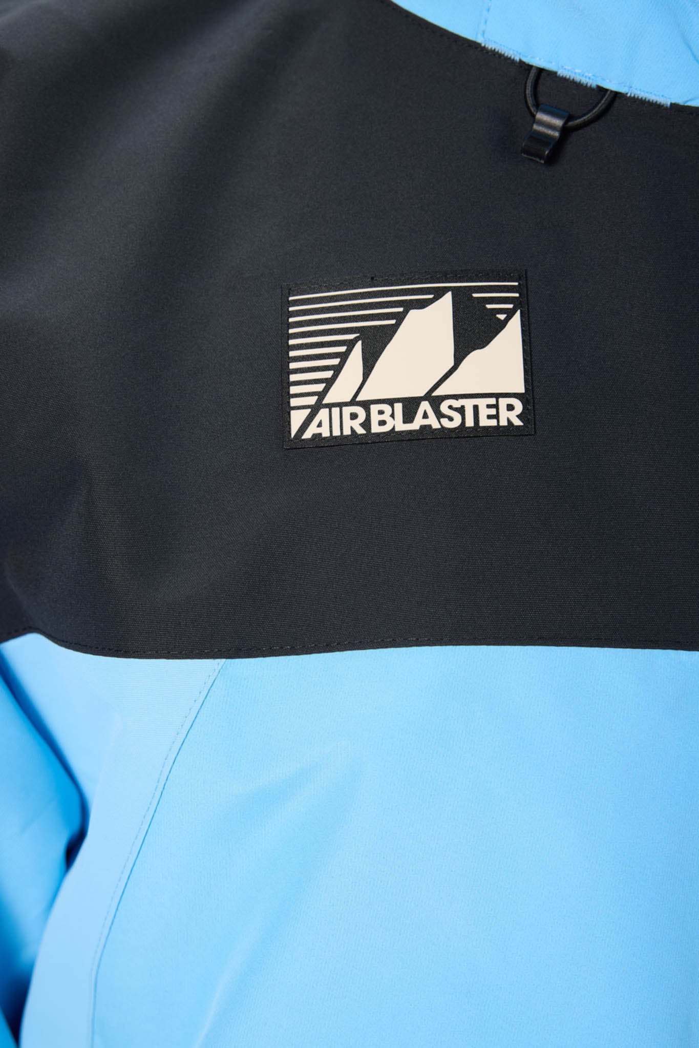 Close-up of a black and blue jacket with 'Airblaster'  logo.