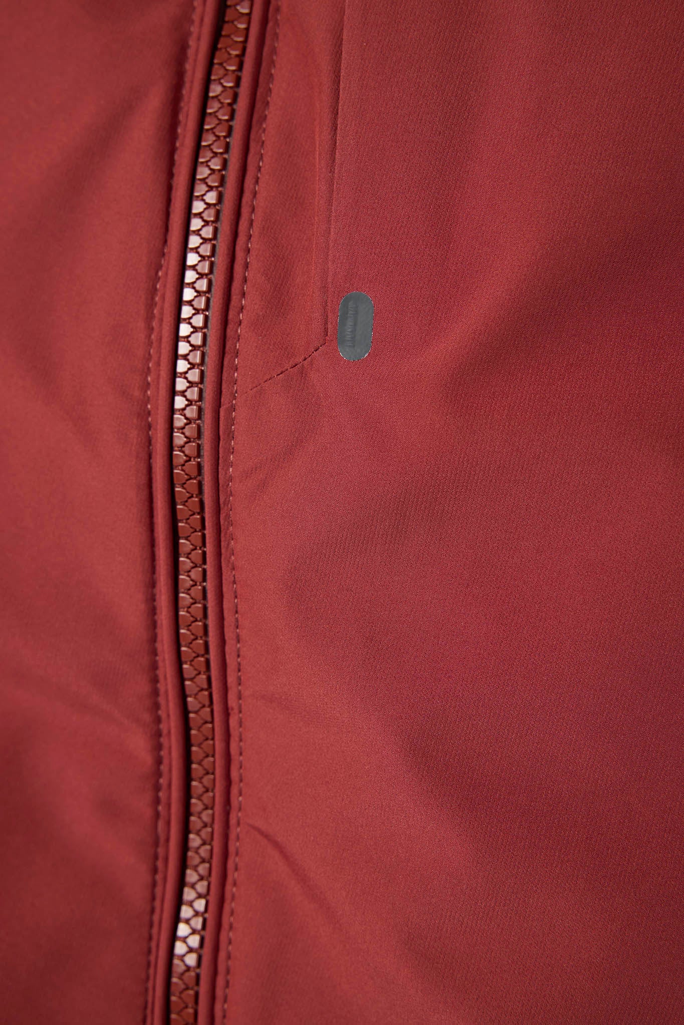 Close-up of a maroon jacket with a zipper