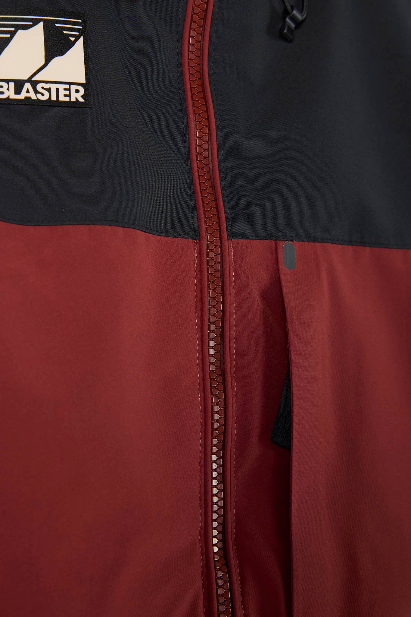 Close-up of a jacket with a brand logo on a plain background