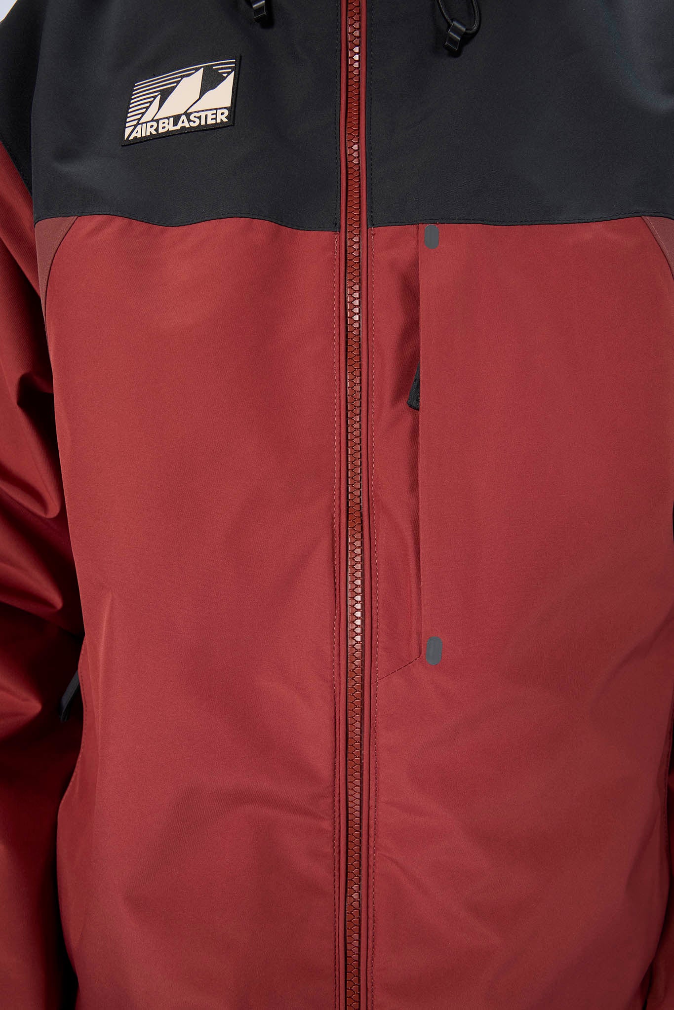 Close-up of a jacket with a visible brand logo on a black and red background