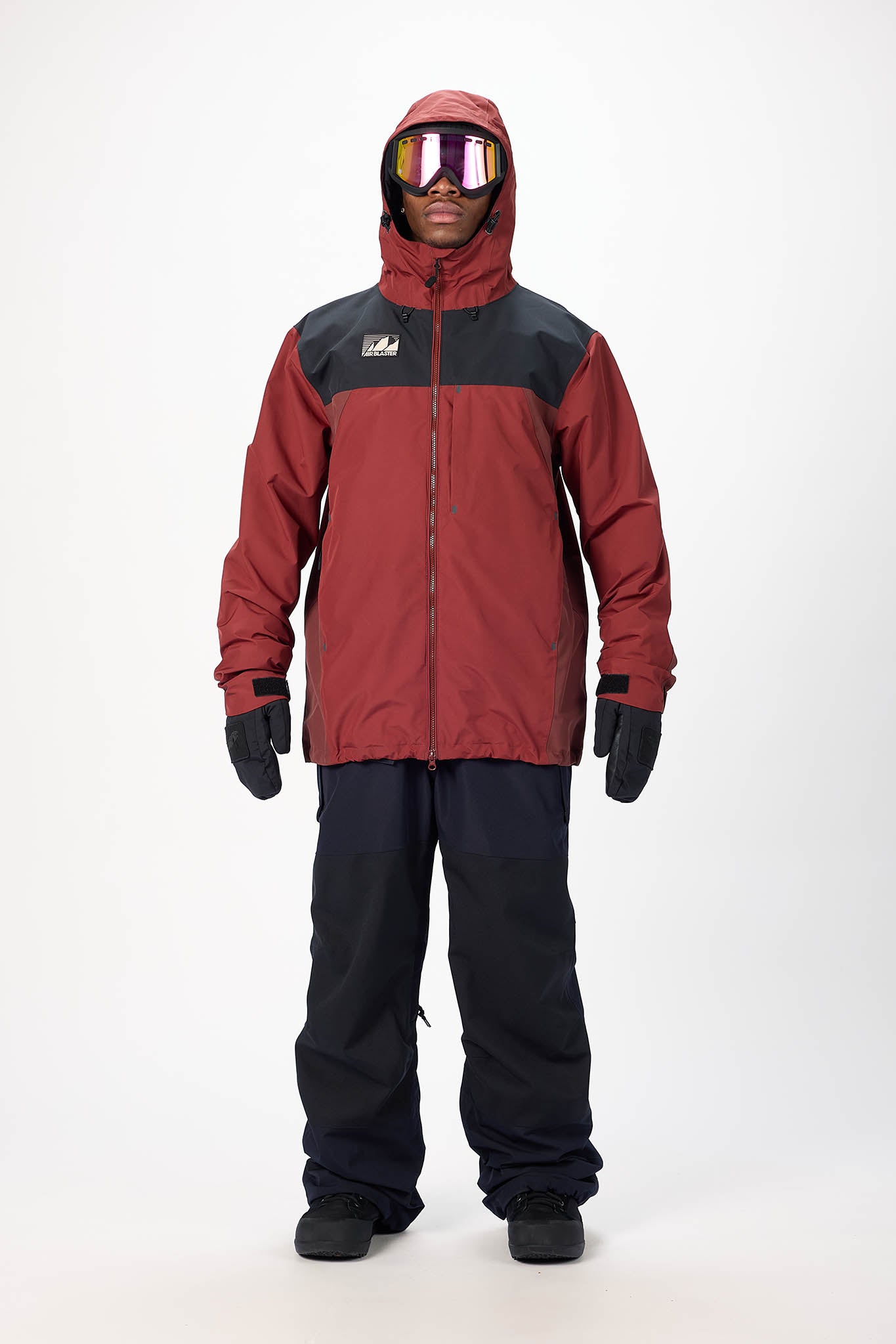 Person wearing a red and black snowsuit with goggles on a white background