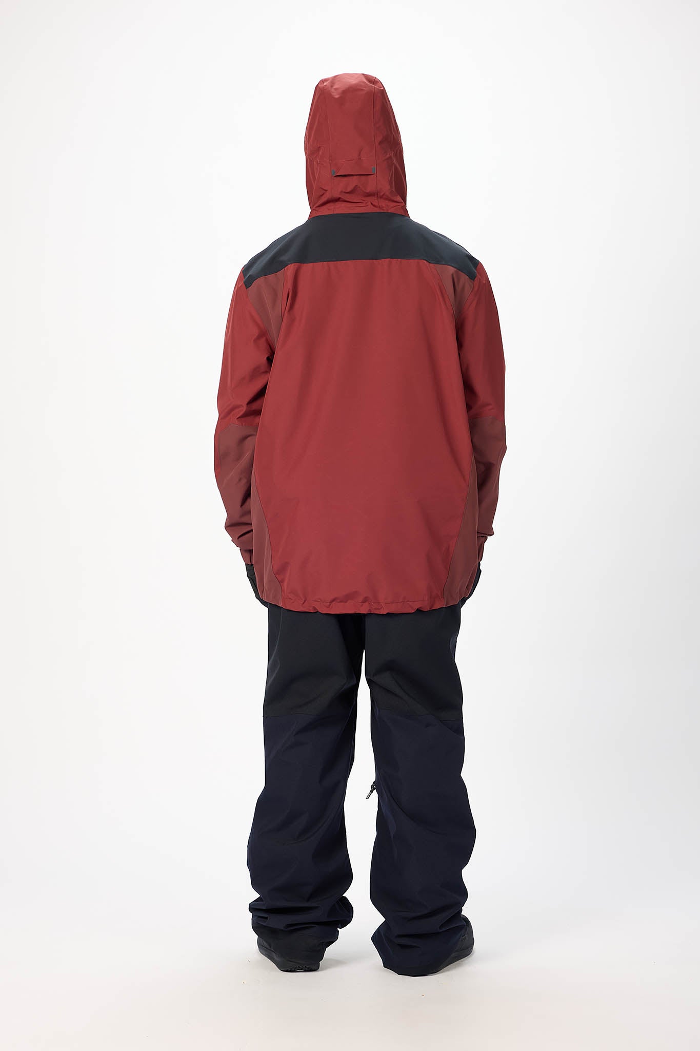 Person wearing a red and black jacket with a hood on a white background