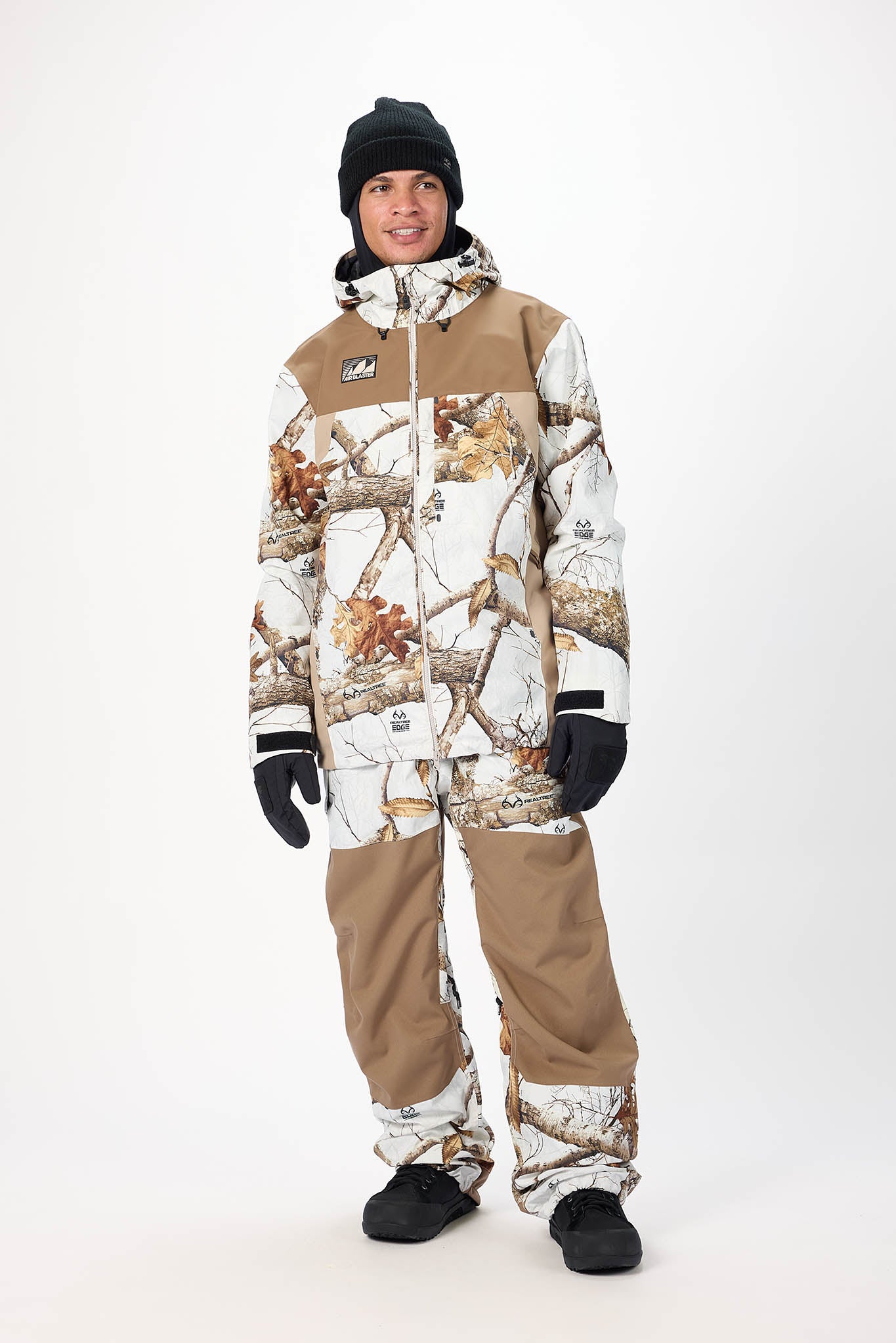 Person wearing a camouflage snowsuit with a brand logo on a white background
