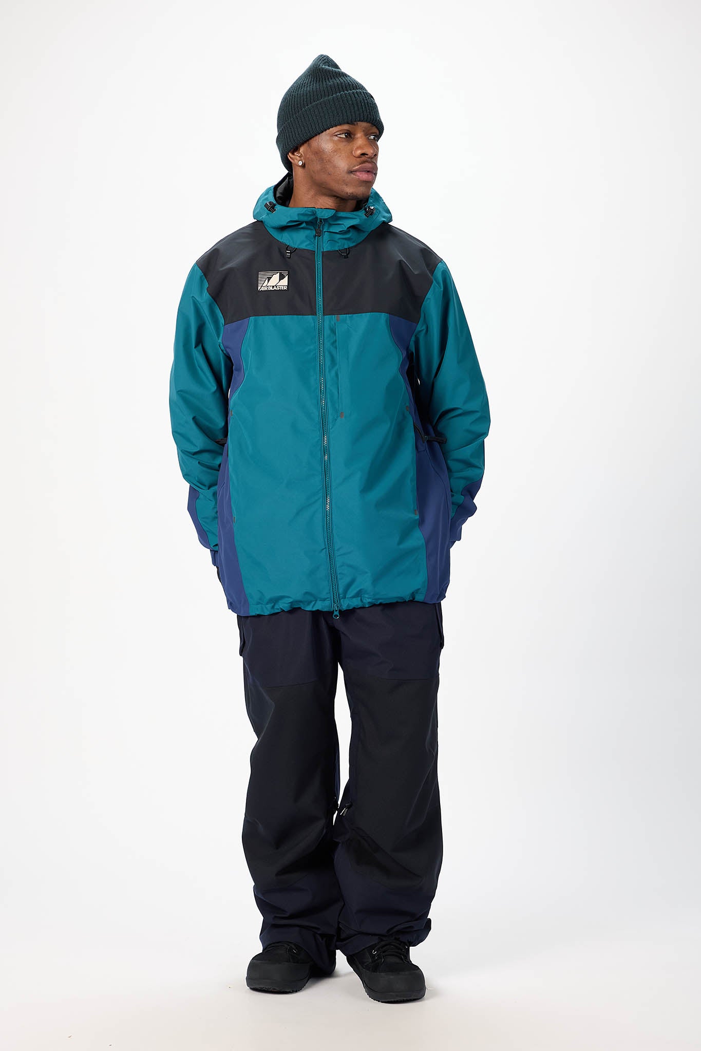 Person wearing a teal and black jacket with a logo on a white background