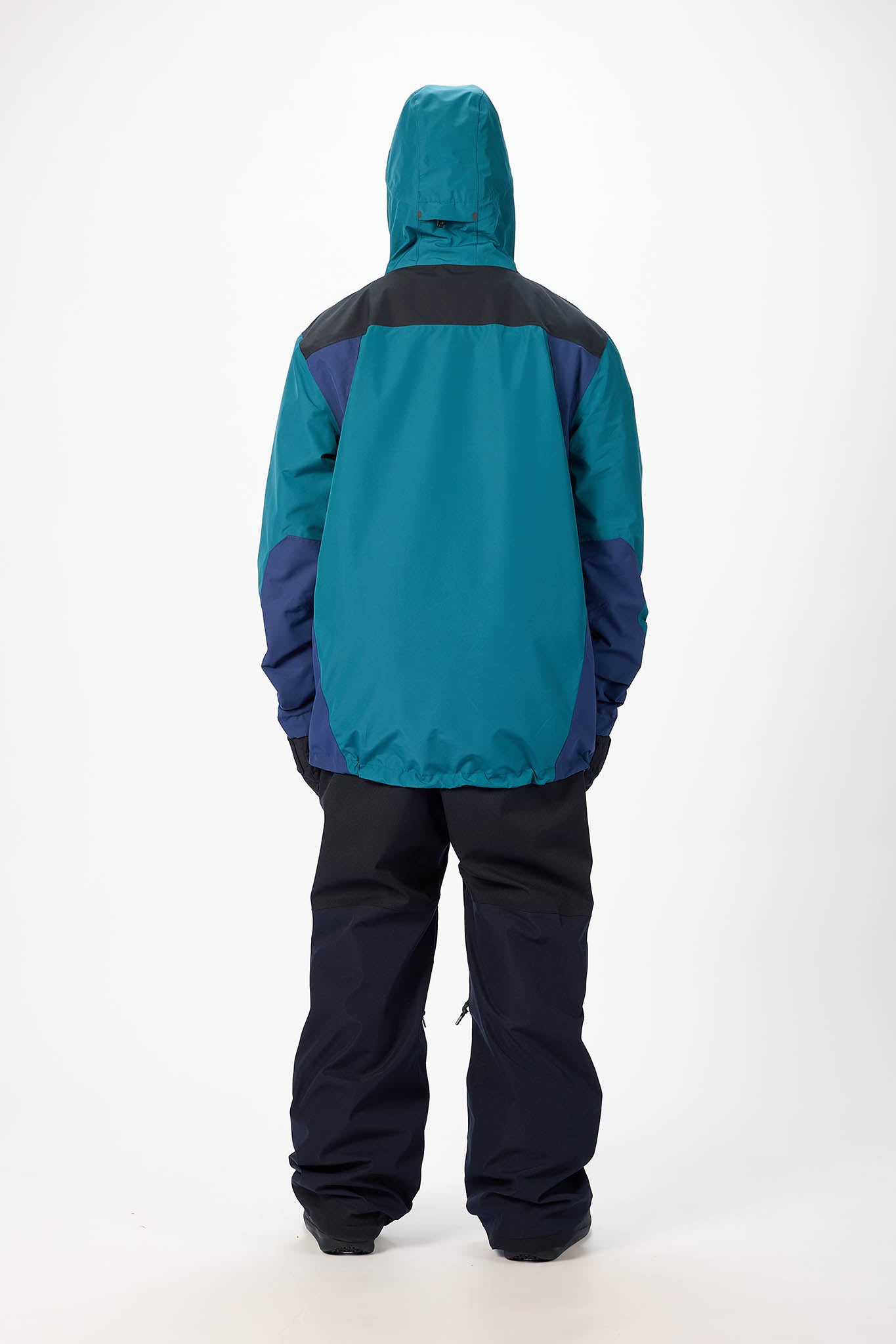Person wearing a teal and black snowsuit on a white background
