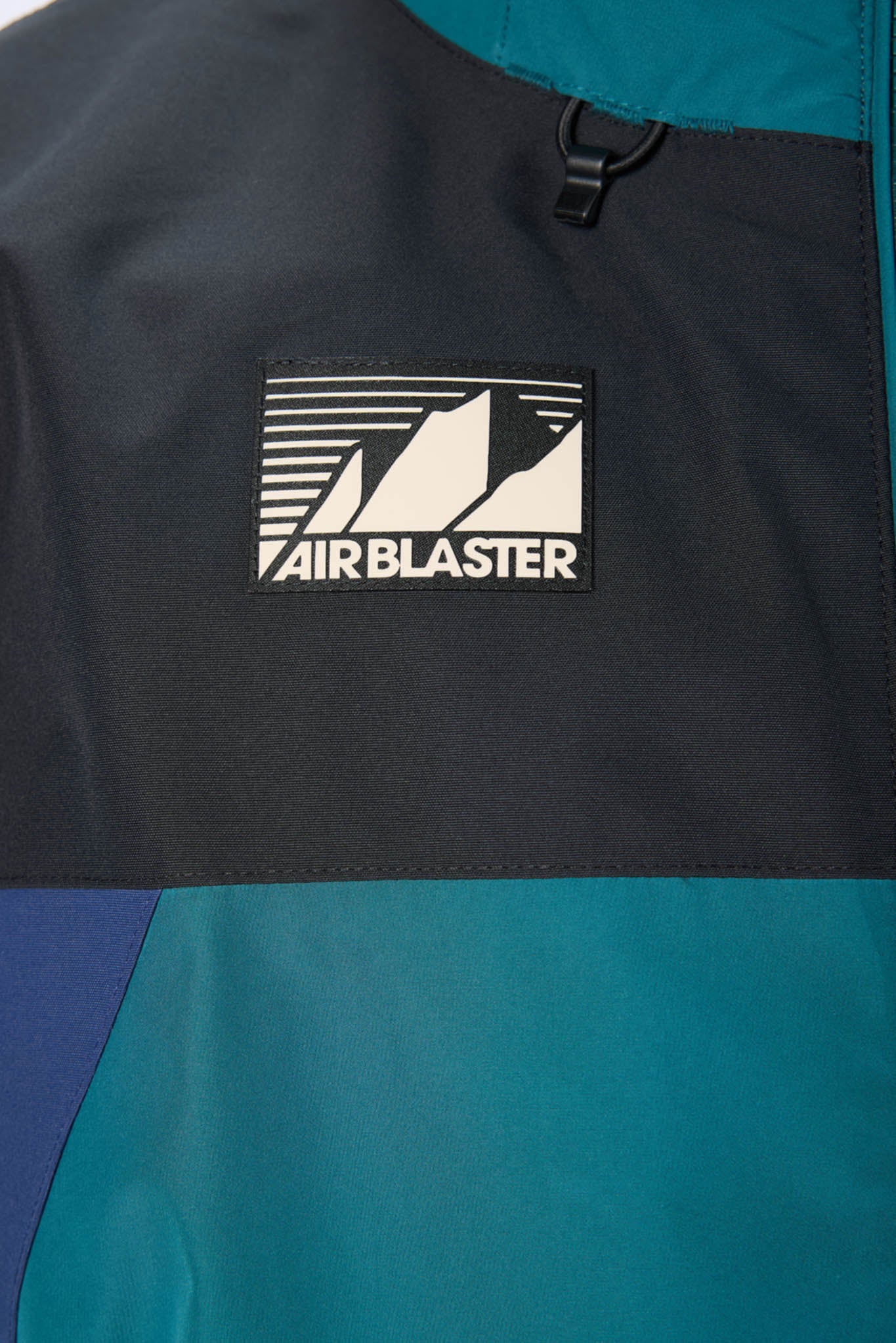 Close-up of a black and blue jacket with 'Air Blaster' logo.