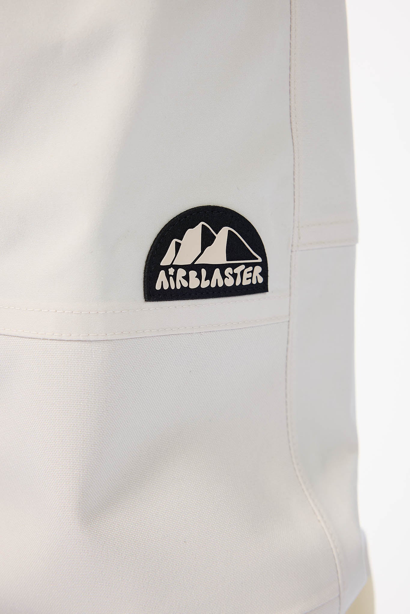 Close-up of a white garment with an Airblaster logo on a white background