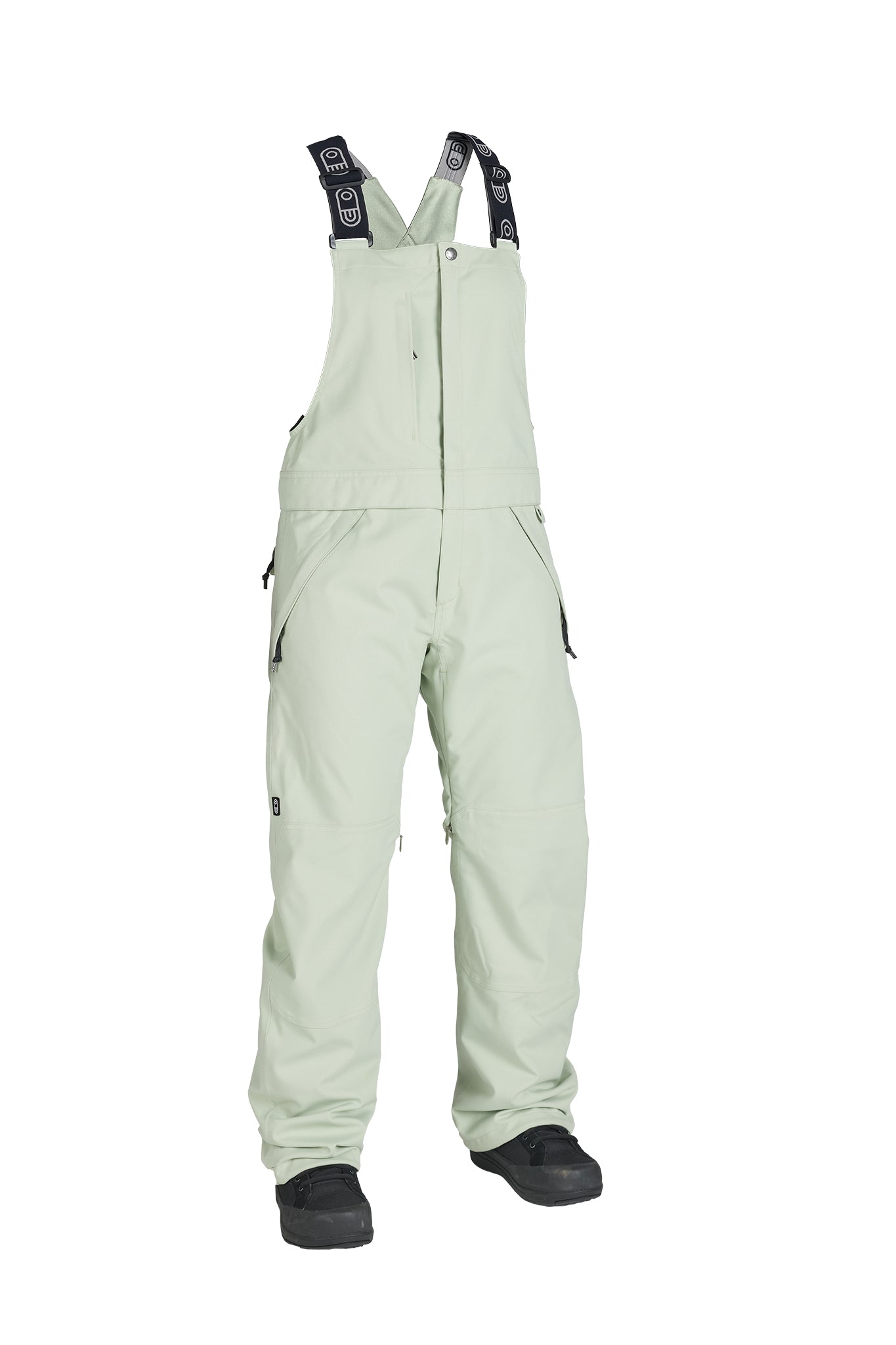 A pair of light sage green snow bib pants with black adjustable shoulder straps and black foot coverings, shown against a plain white background.