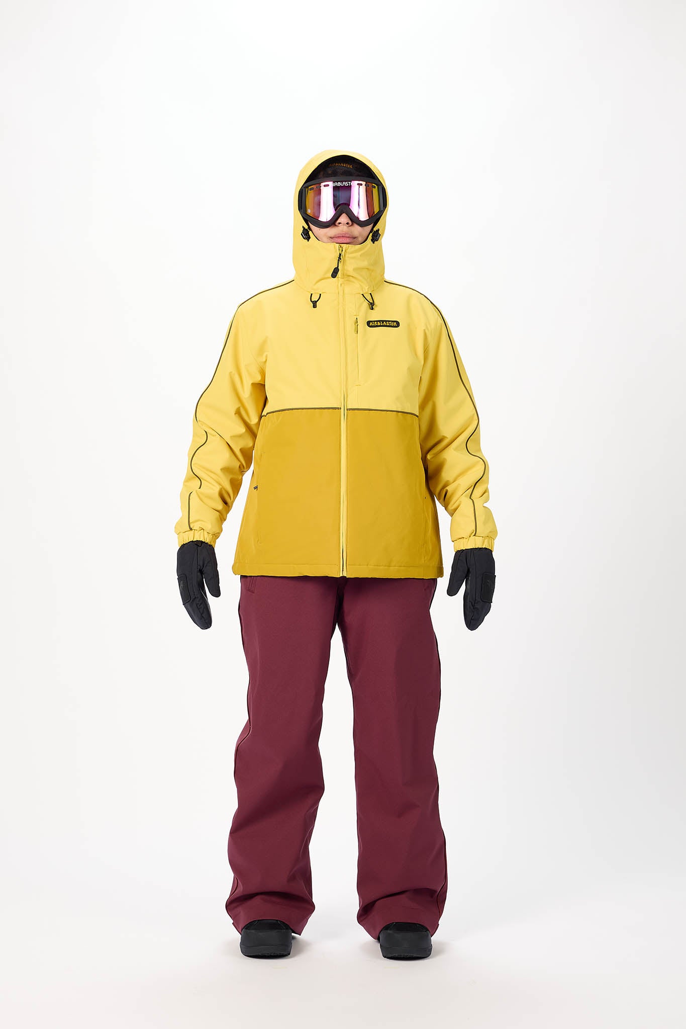 Person wearing a yellow jacket and maroon pants on a white background